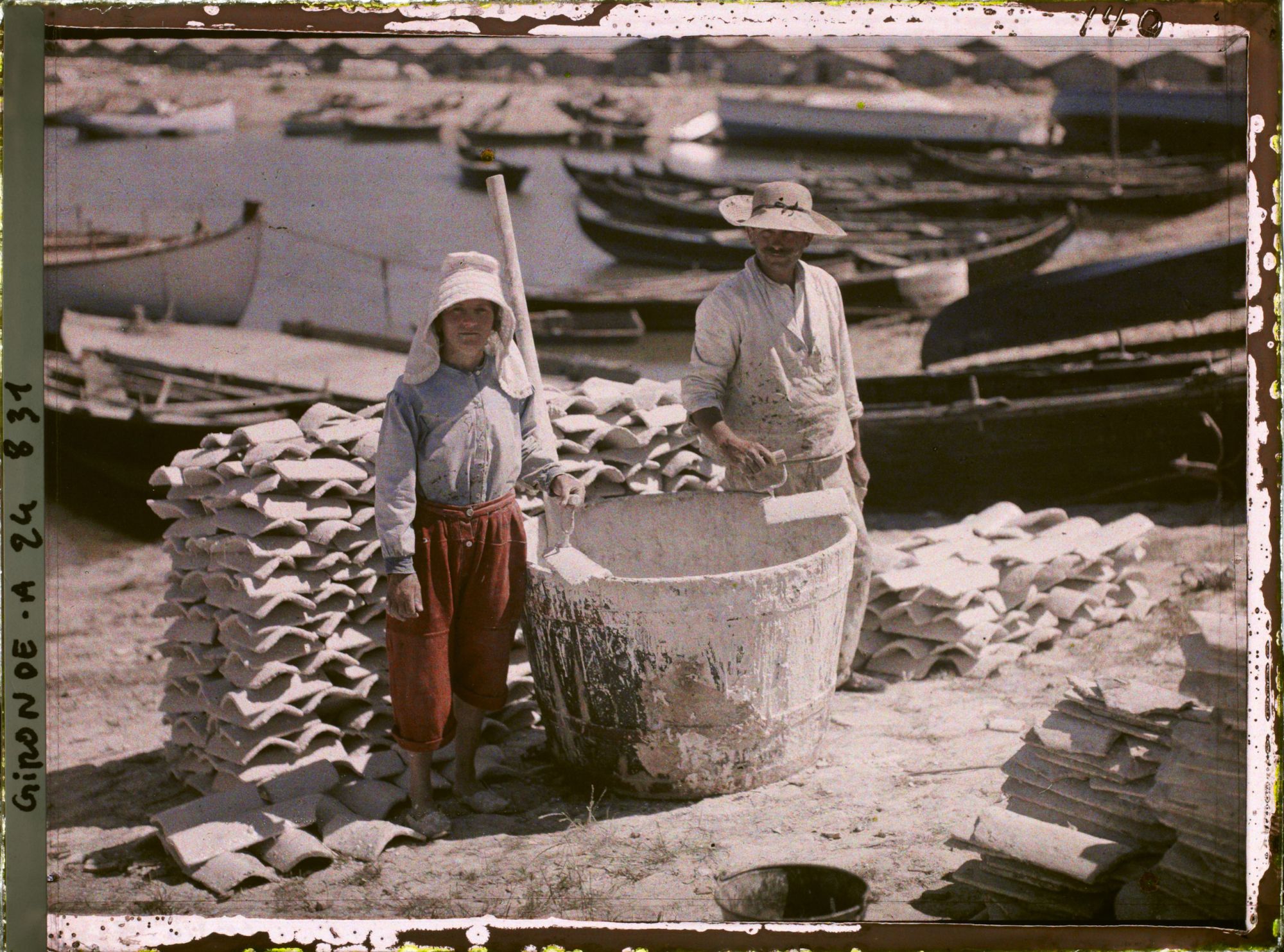 Image représentant Un couple d'ostréiculteurs recouvrant de chaux une tuile pour recueillir les huîtres