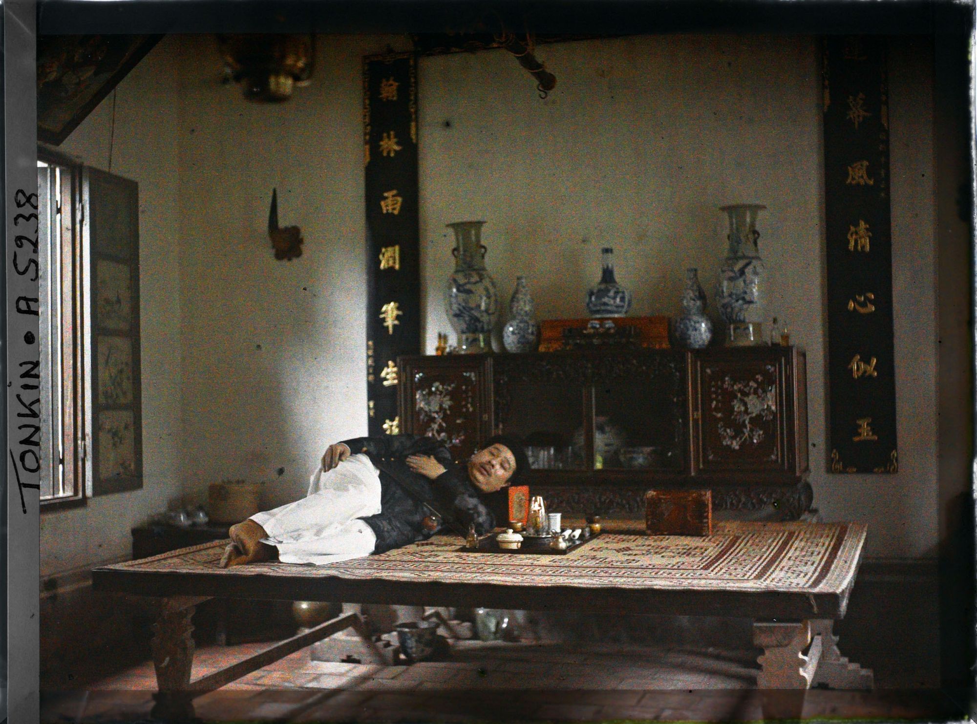 Image représentant Un fumeur allongé dans une fumerie d'opium