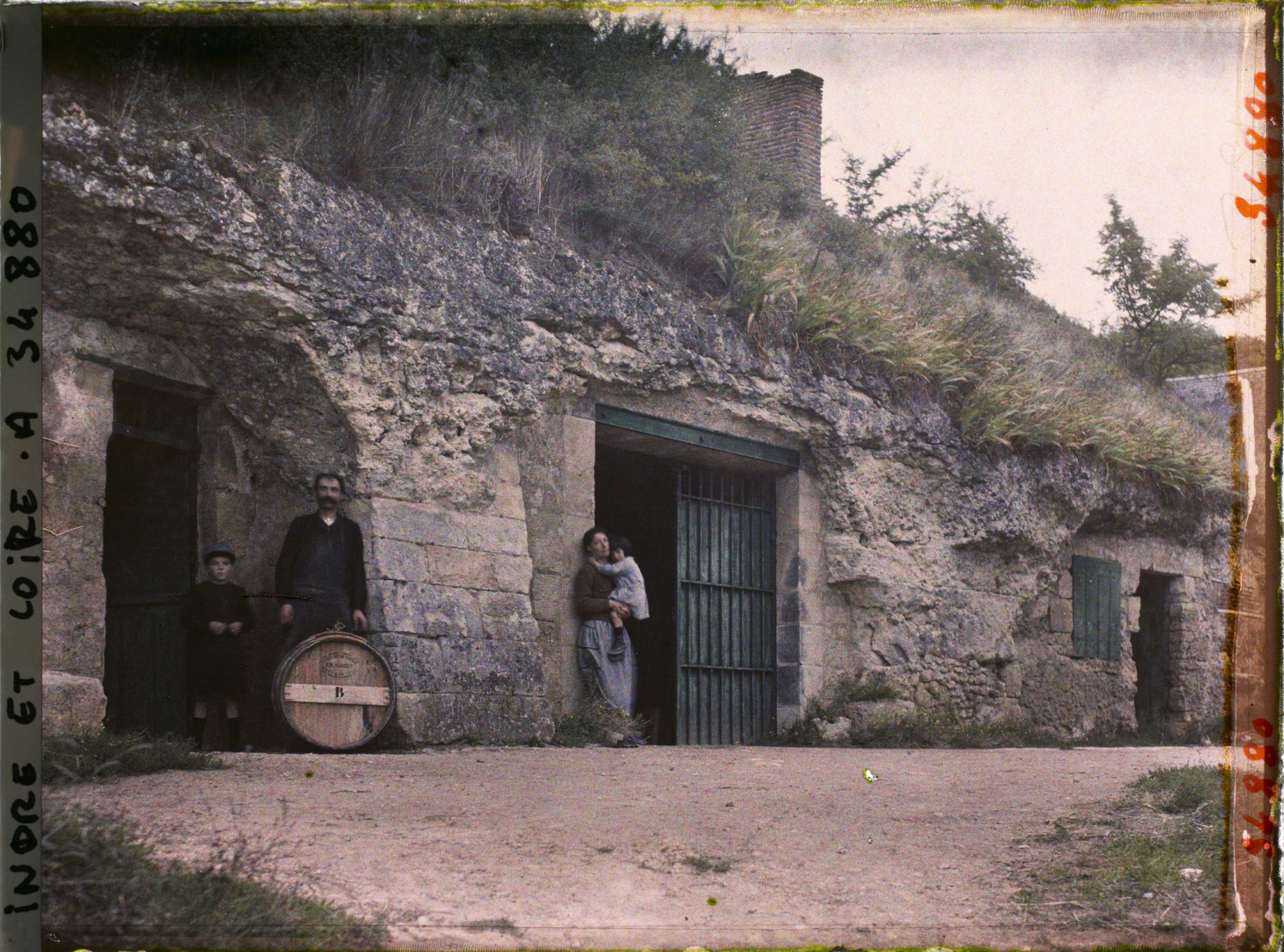 Image représentant Homme, Femme et enfants posant devant une cave troglodyte