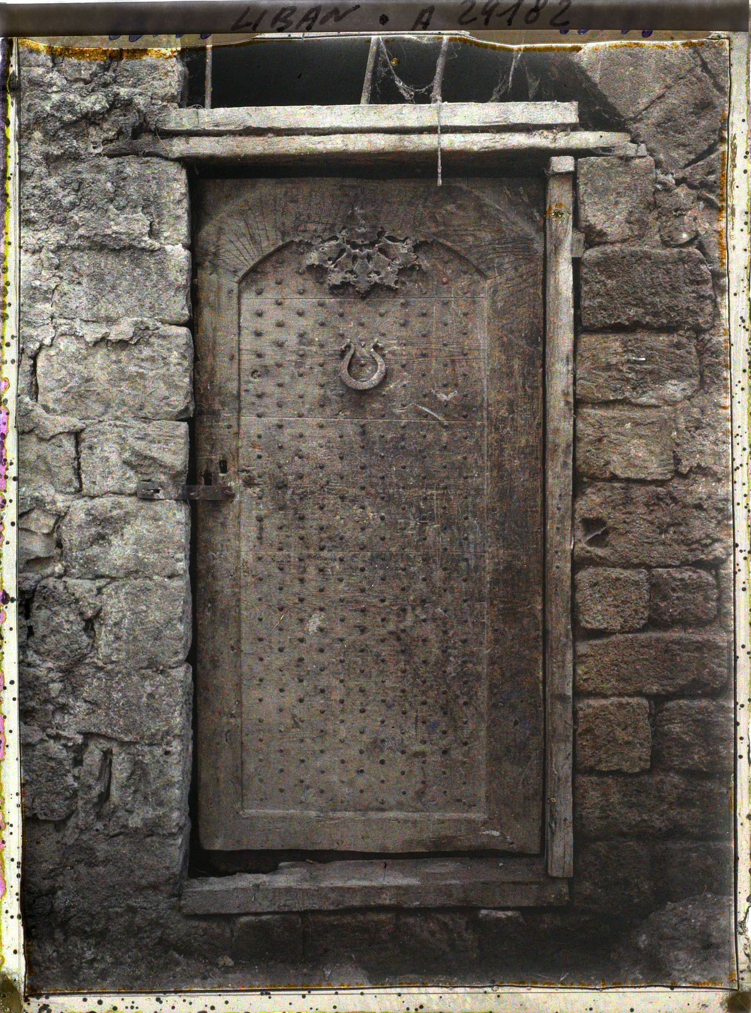 Image représentant Porte ancienne de bois clouté dans une cour d'église