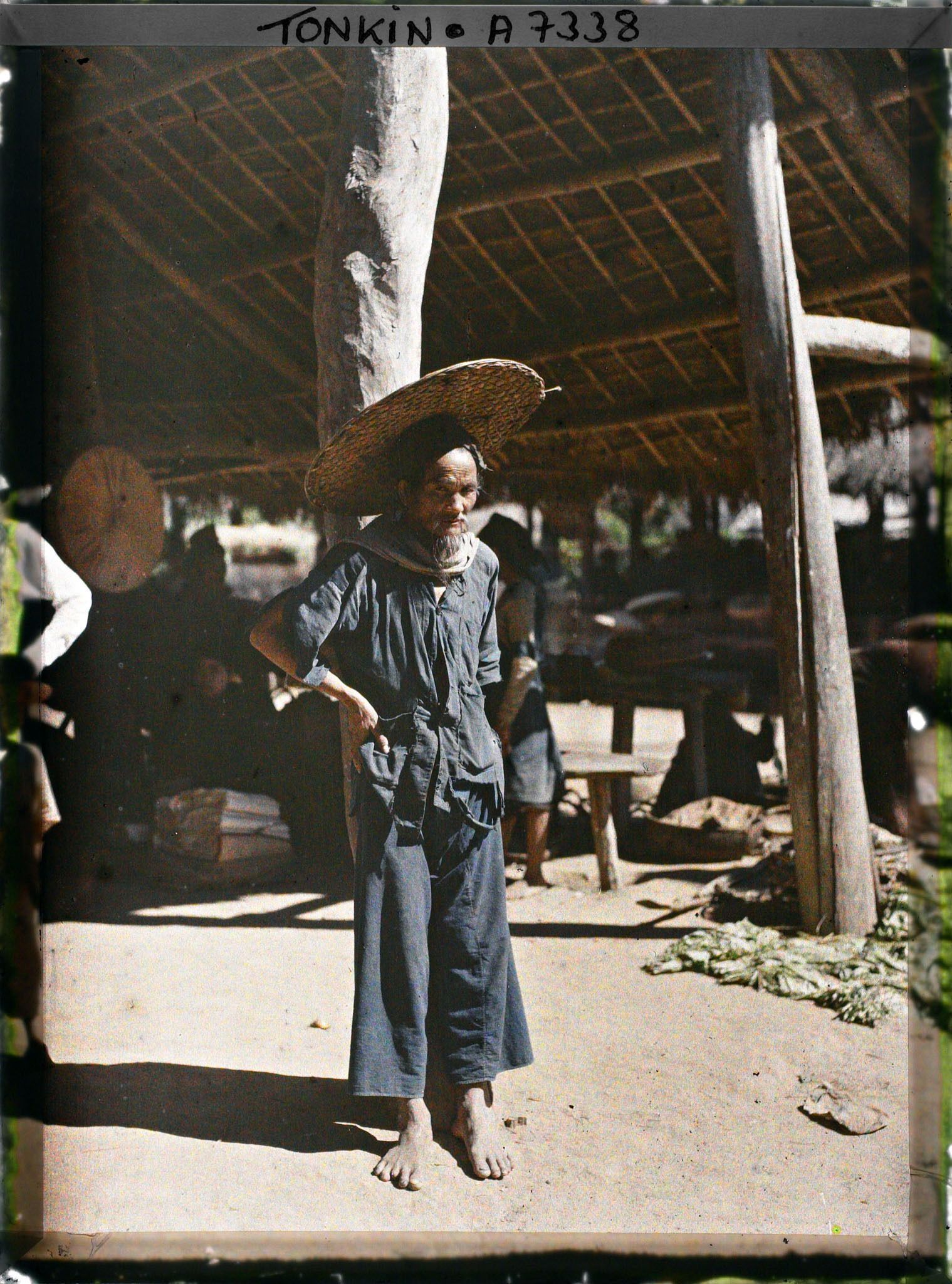 Image représentant Un vieil homme thô, vêtu de bleu, au marché