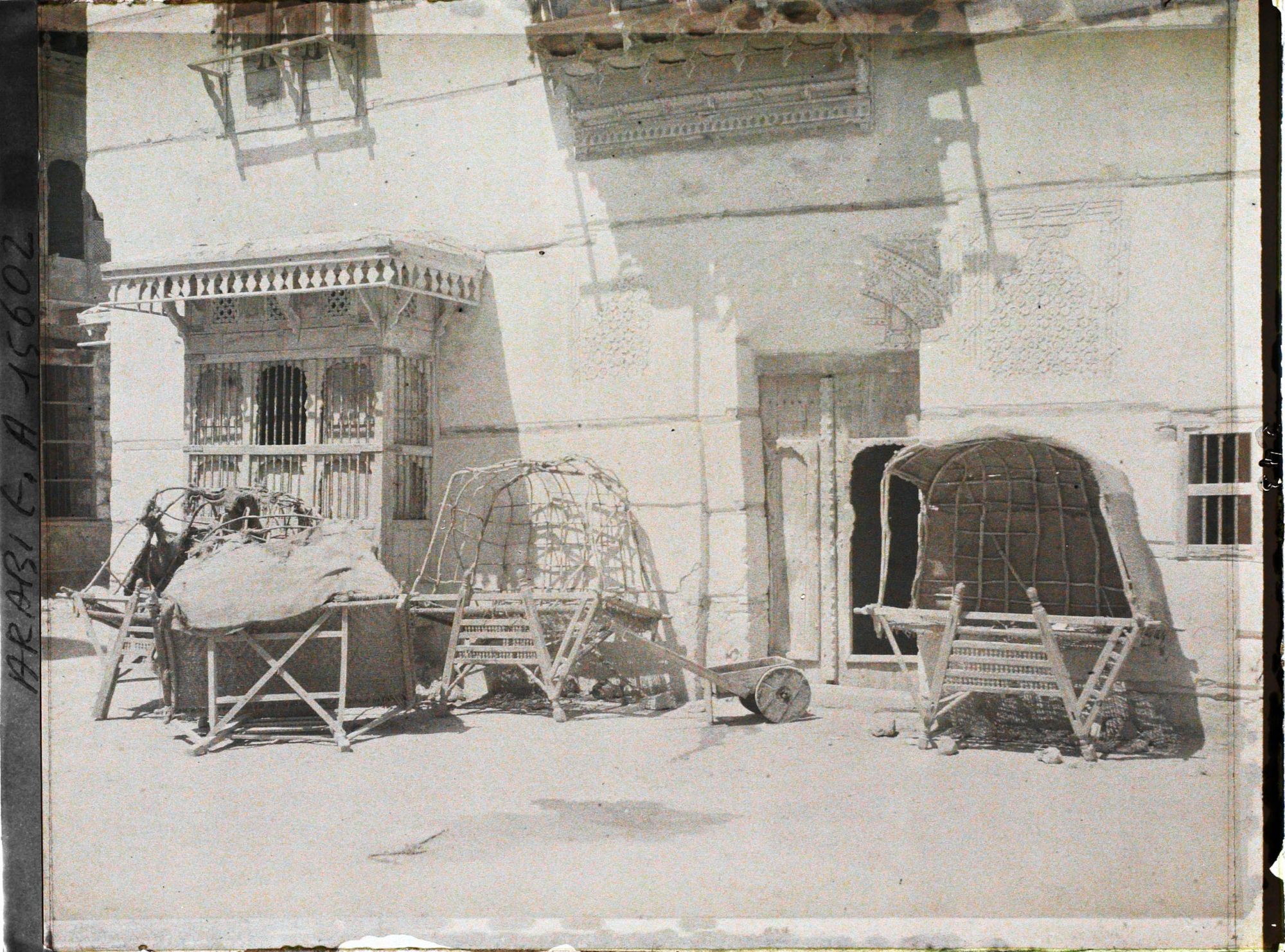 Image représentant Selles à chameaux couvertes, devant une maison
