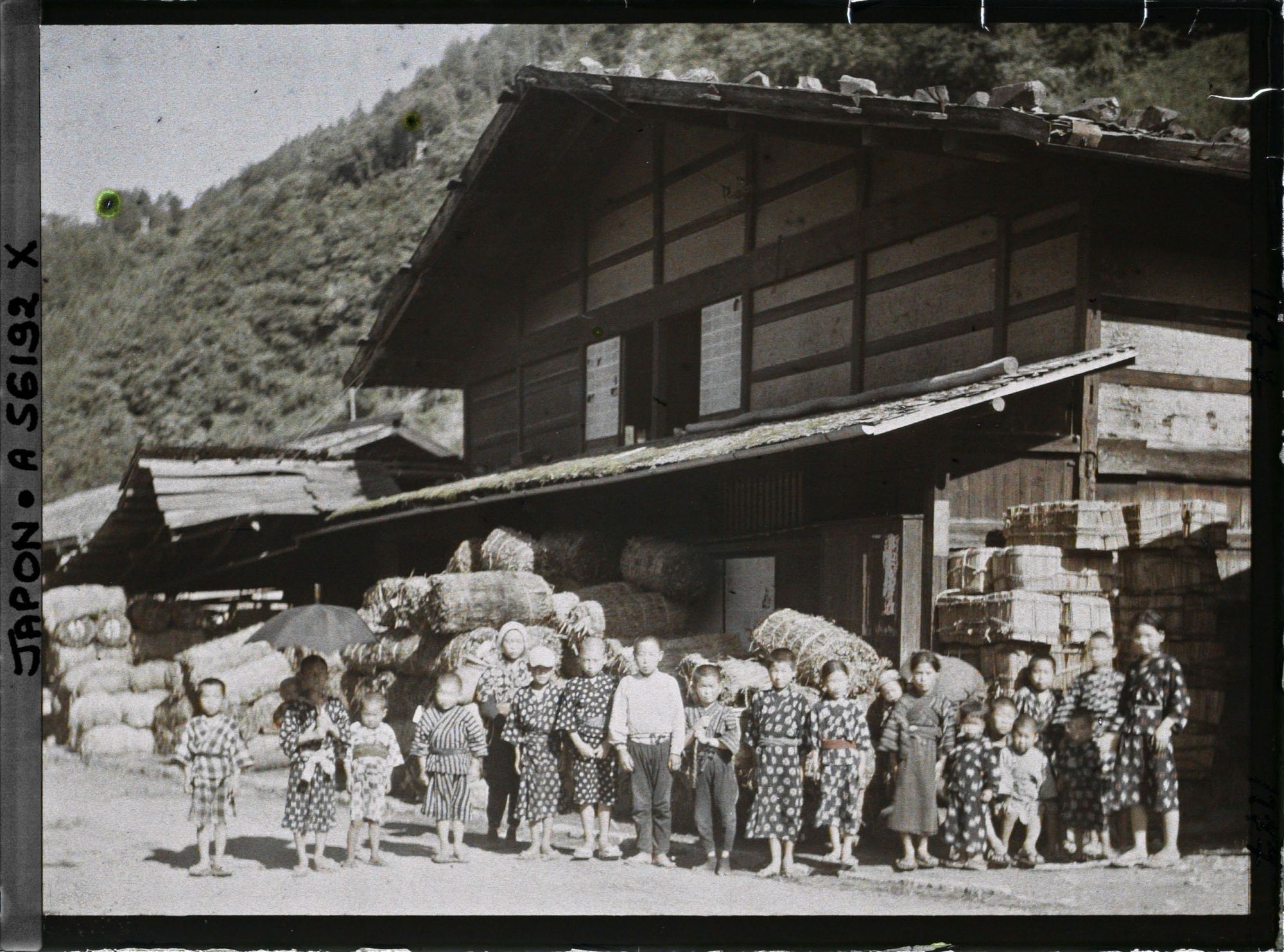 Image représentant Groupe d'enfants devant la maison d'un marchand de charbon et de bardeaux
