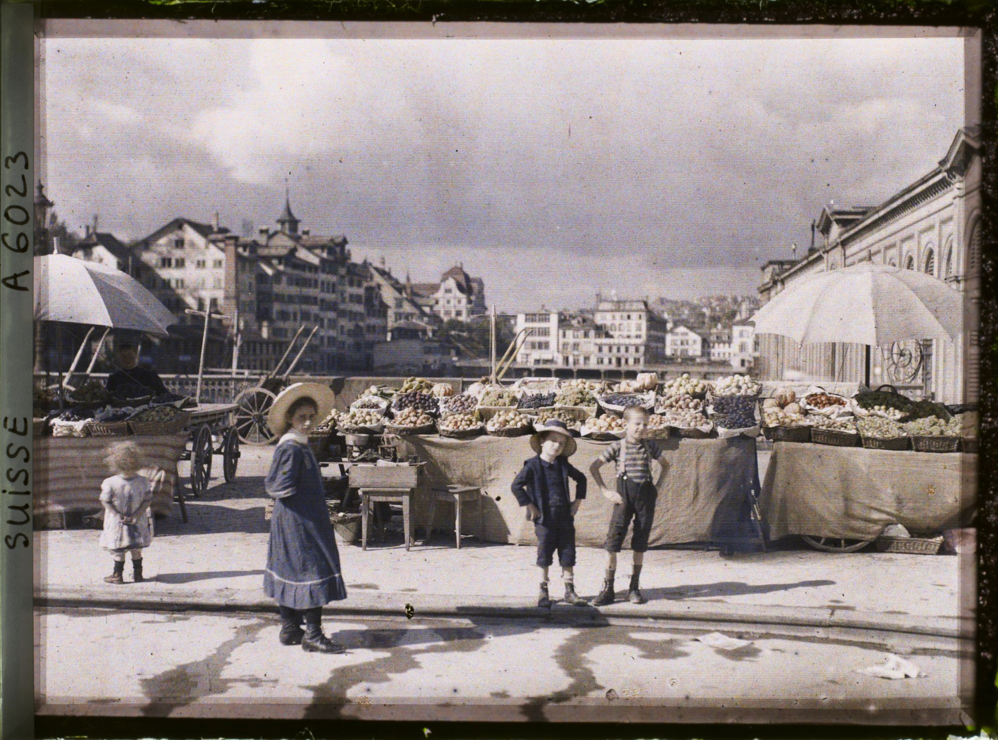Image représentant Quatre enfants posent sur le Rathausbrücke où se tient un marché aux légumes