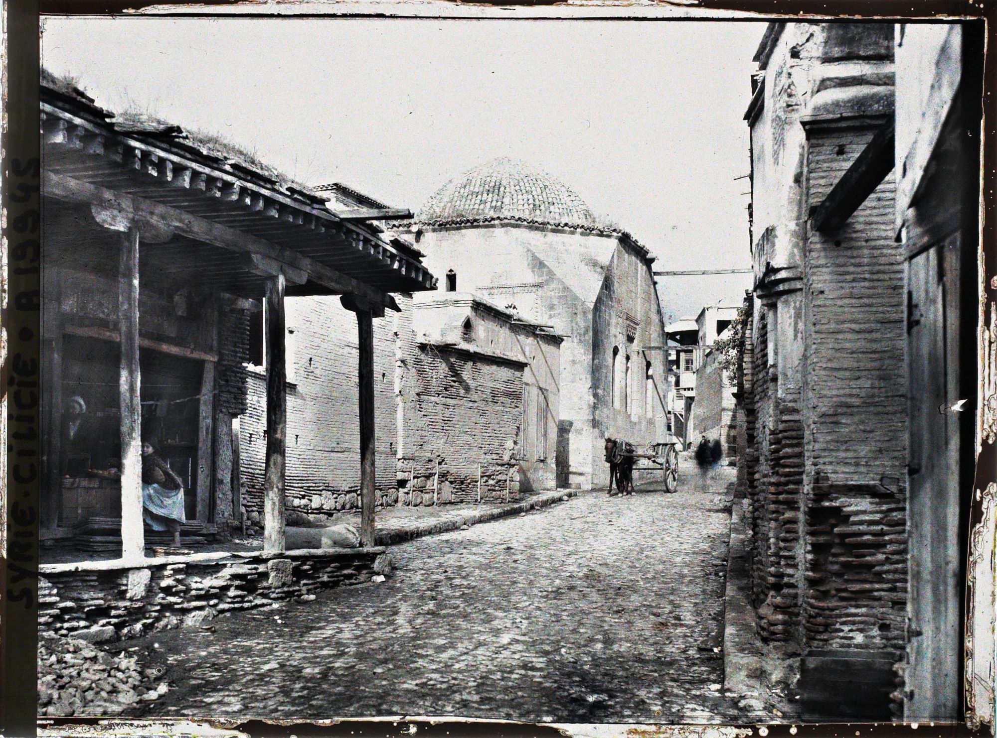 Image représentant À gauche une boutique, au fond, la coupole d'une école coranique