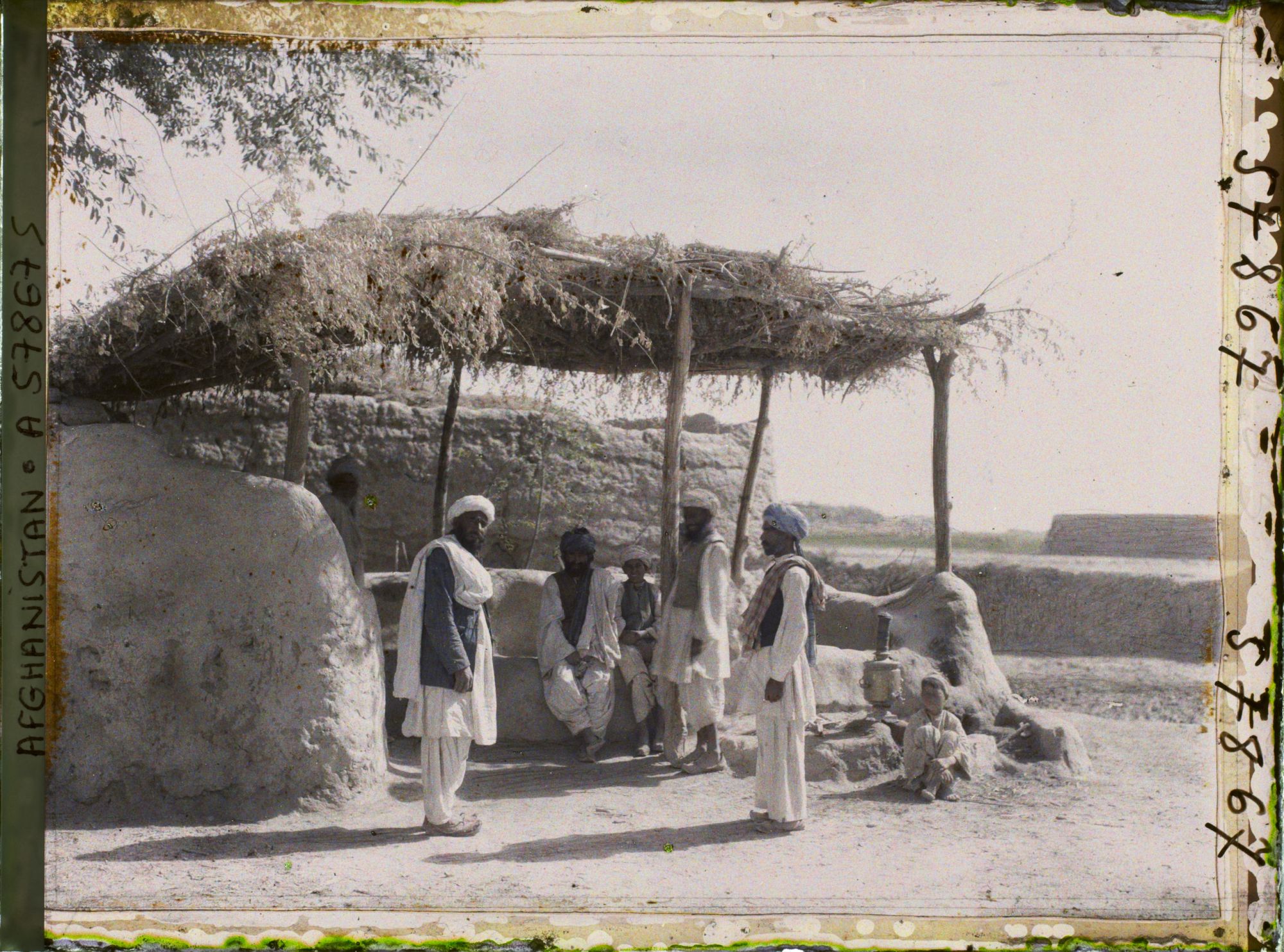 Image représentant Hommes en discussion sous un auvent de maison de thé