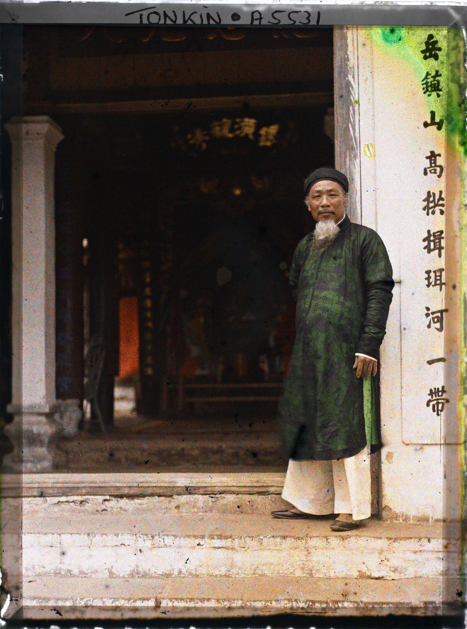 Image représentant Un chef de canton devant la porte du Dinh (maison communale)