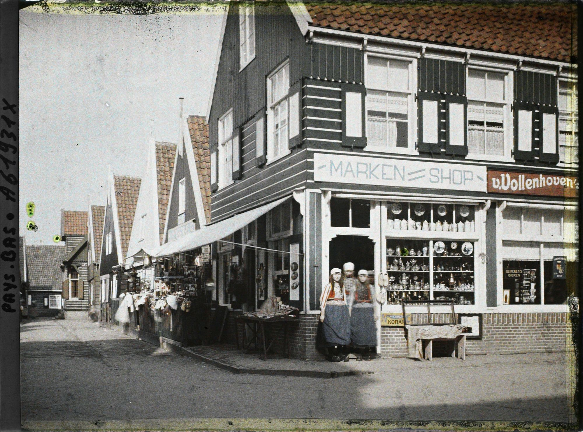 Image représentant jeunes filles en costume de l'île à l'entrée d'un magasin de souvenirs