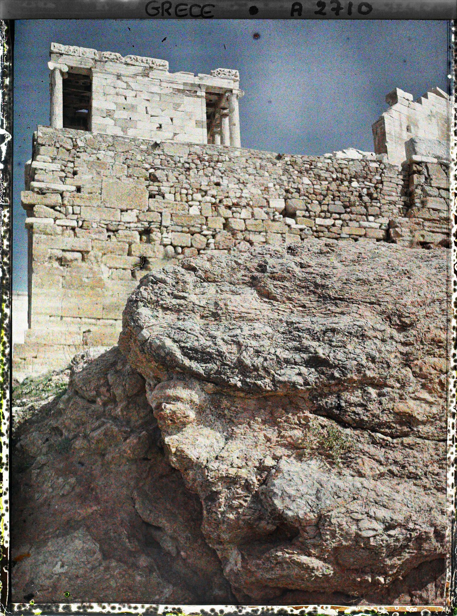 Image représentant L'extrémité ouest de l'Acropole avec le Temple d'Athéna Nike (profil sud). (A droite, vestige du sanctuaire d'Artemis Brauronia)