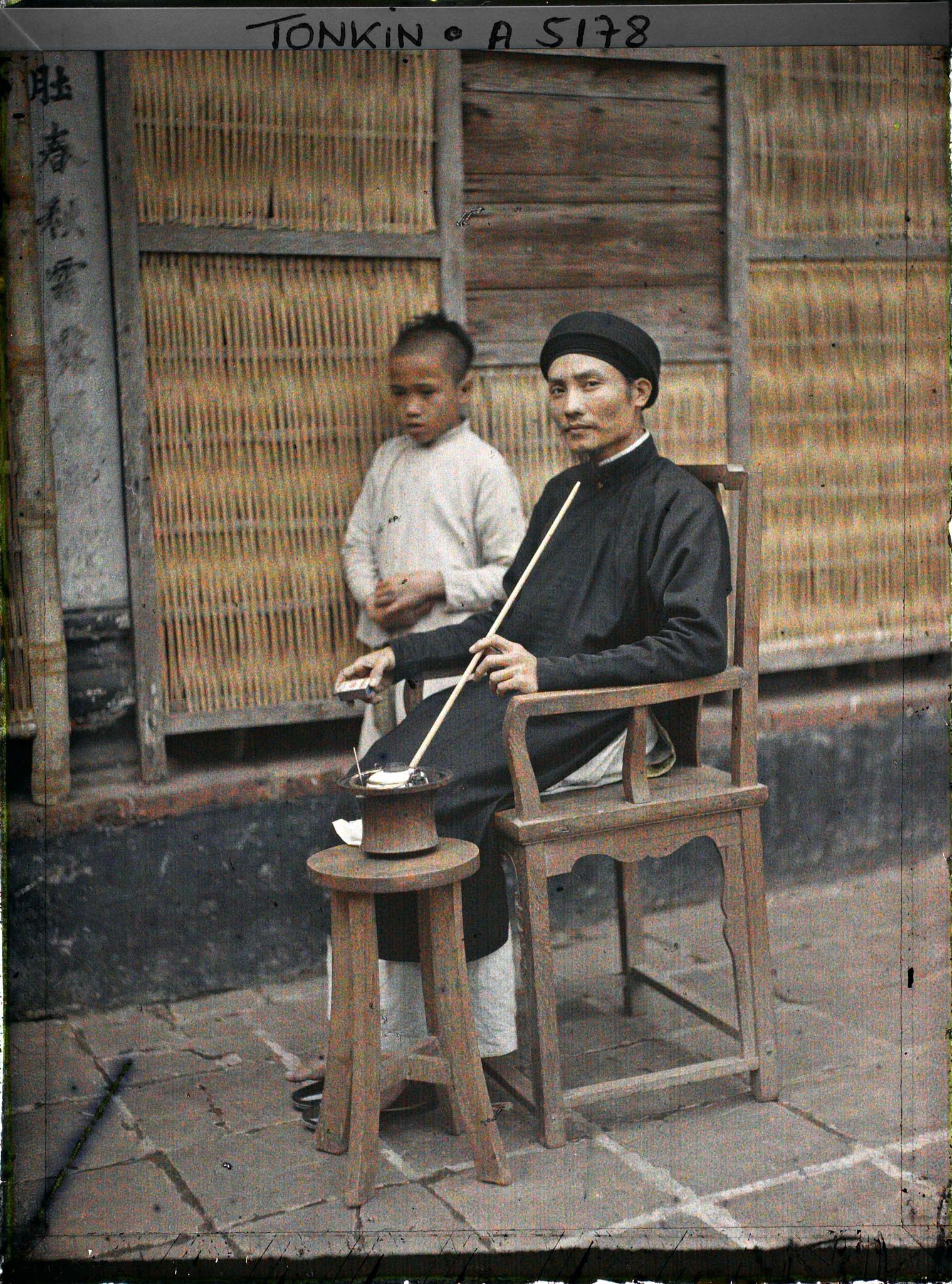 Image représentant Un maire de village fumant sa pipe à eau dans la cour intérieure de sa maison
