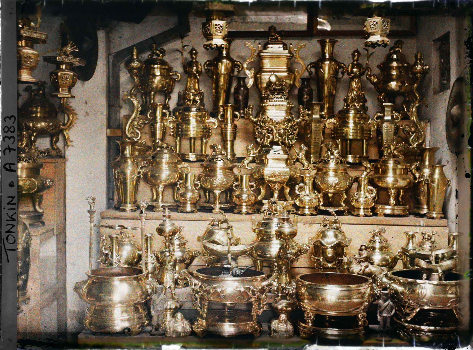 Image représentant Un étalage d'objets en cuivre (trépieds, vases...), à l'intérieur d'une boutique, dans la " rue du Cuivre "