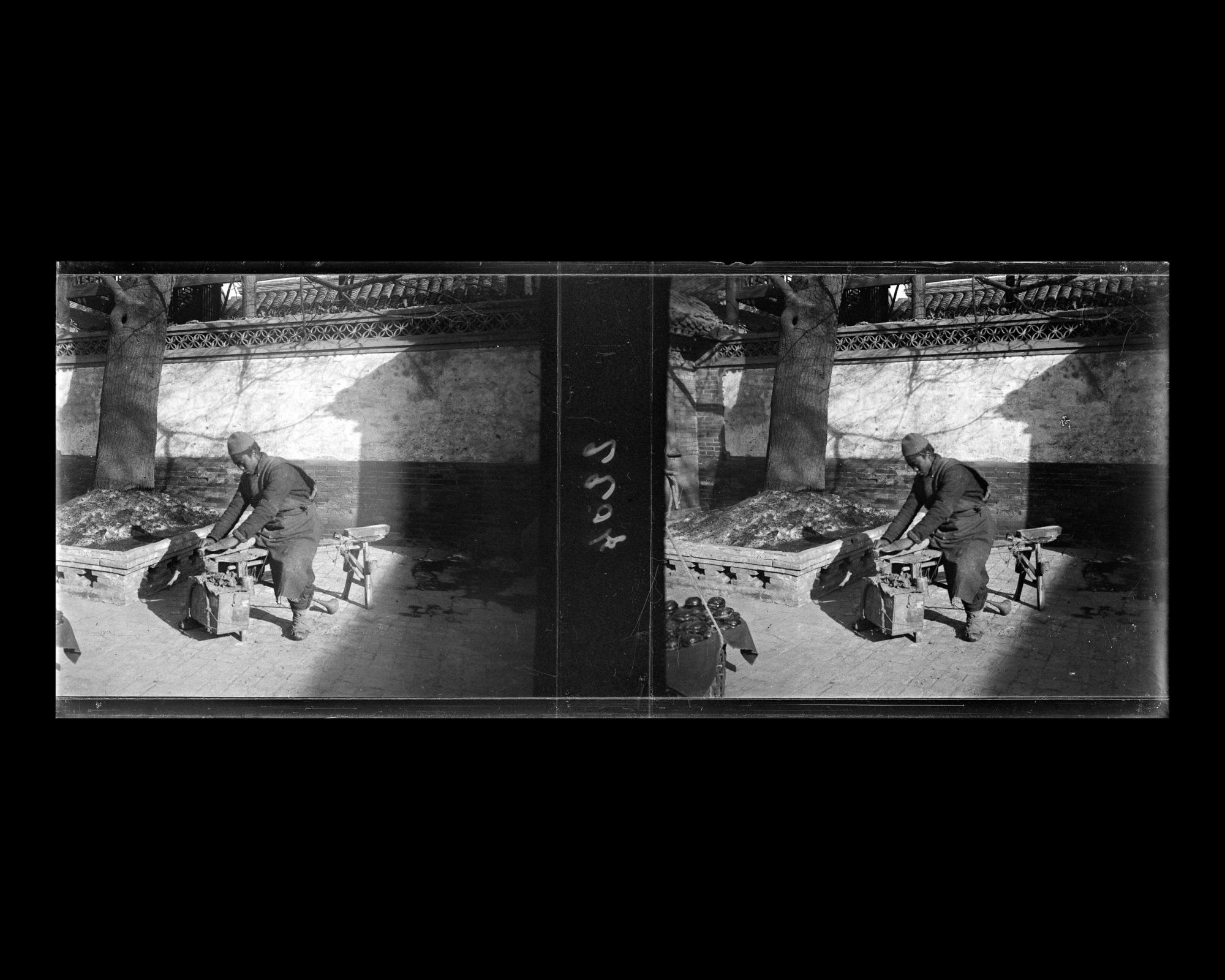 Image représentant Un rémouleur au travail dans la première cour d'une résidence (siheyuan) de Da Ruanfuhutong ("Grande Ruelle de la Résidence Ruan")