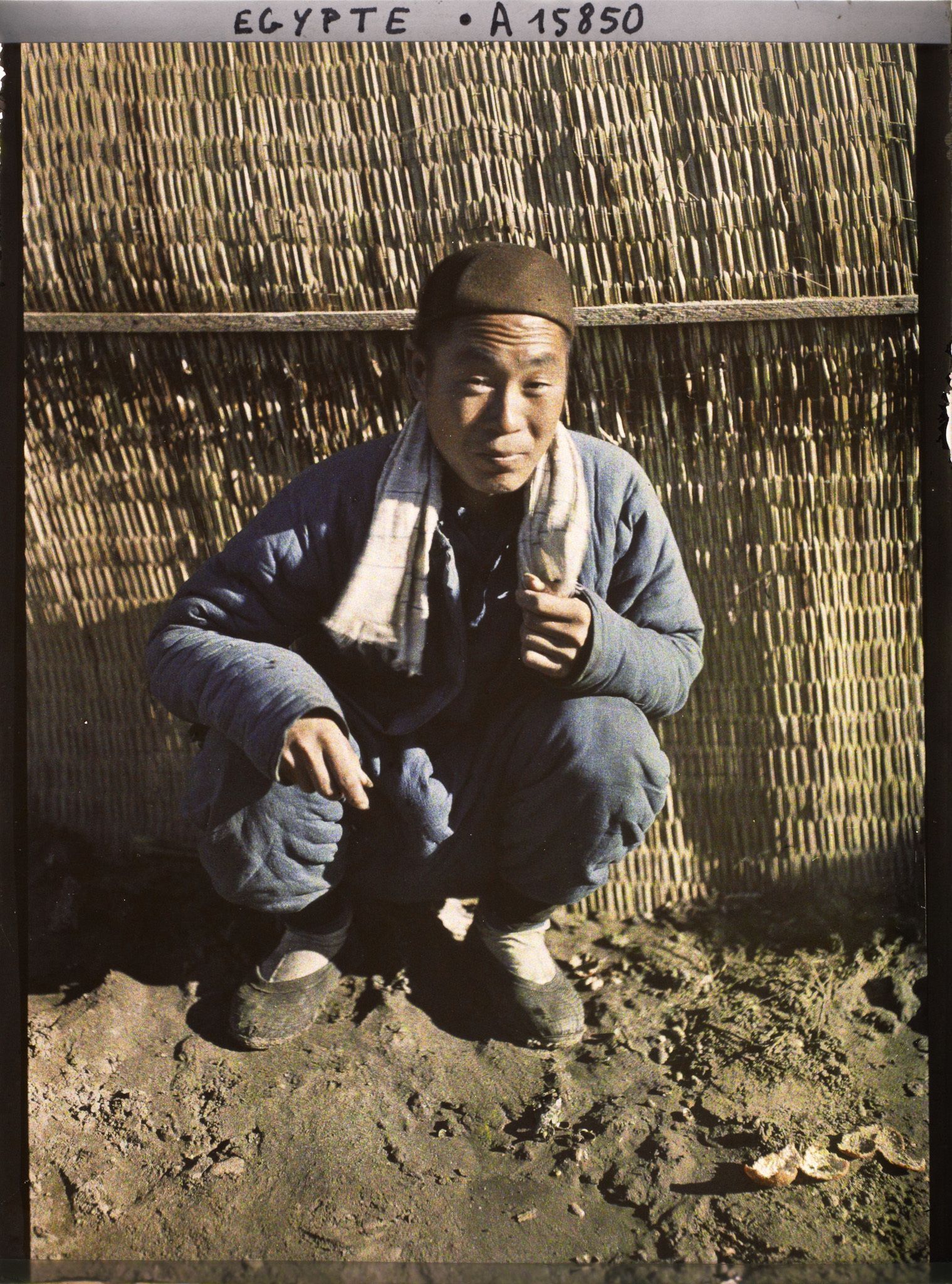 Image représentant Un ouvrier chinois assis, posant pour l'opérateur