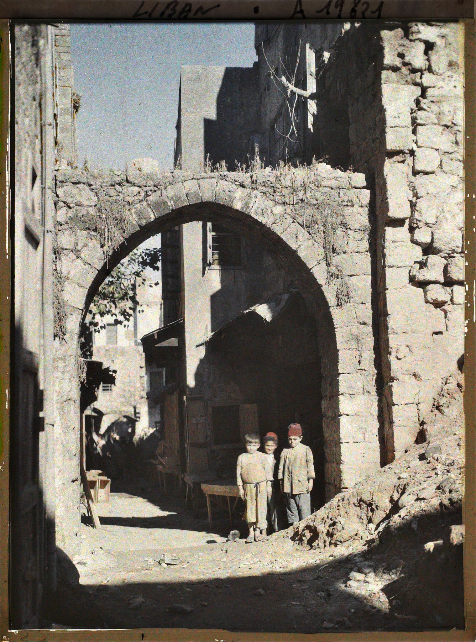 Image représentant Trois garçonnets devant une porte de souks
