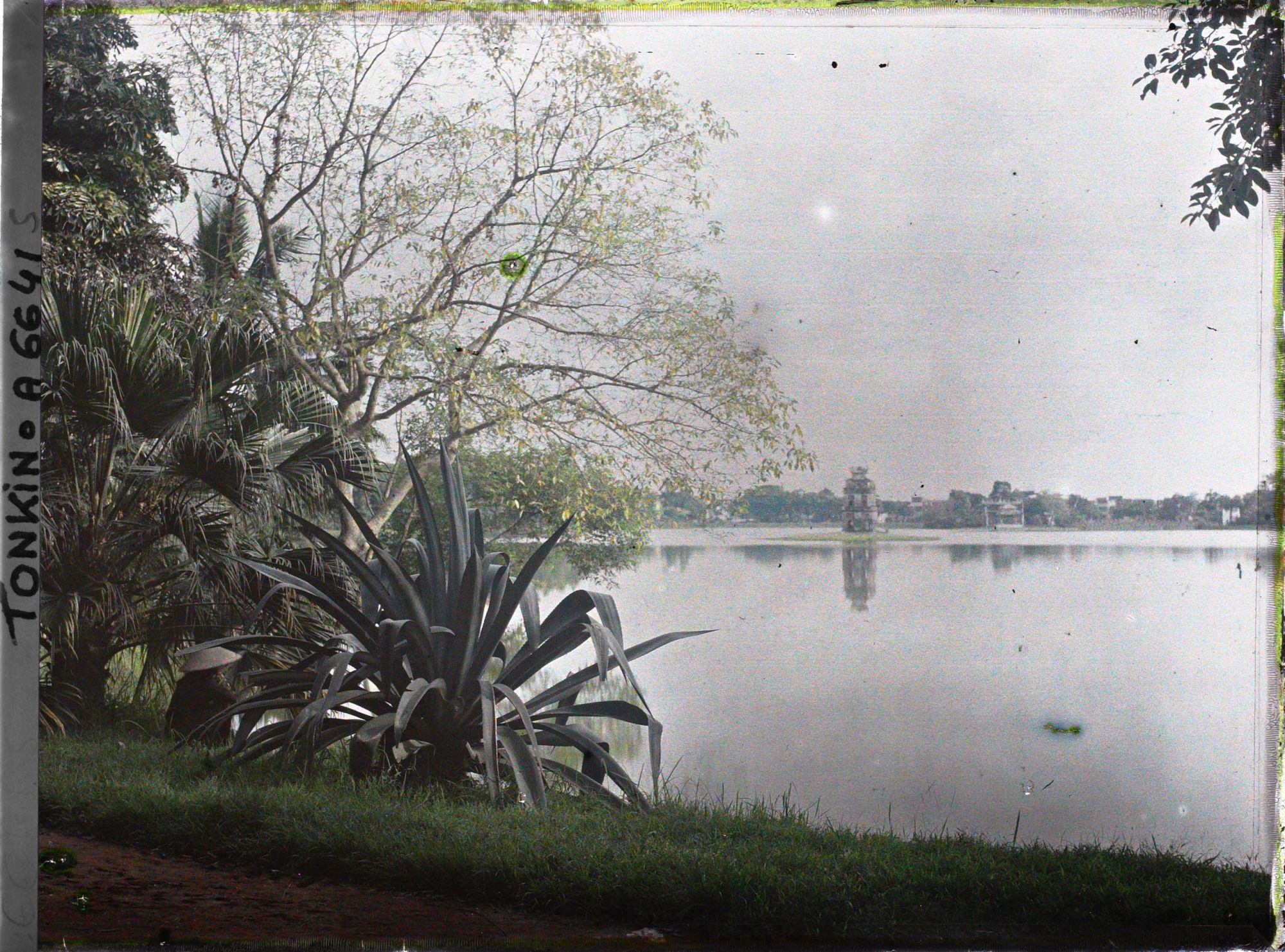 Image représentant Le Petit Lac ou Hoan-kiem-ho ("  Lac de l'épée restituée  "), vu de la rue Paul Bert, vers le pagodon octogonal appelé "  Stûpa de l'île de la Tortue  "