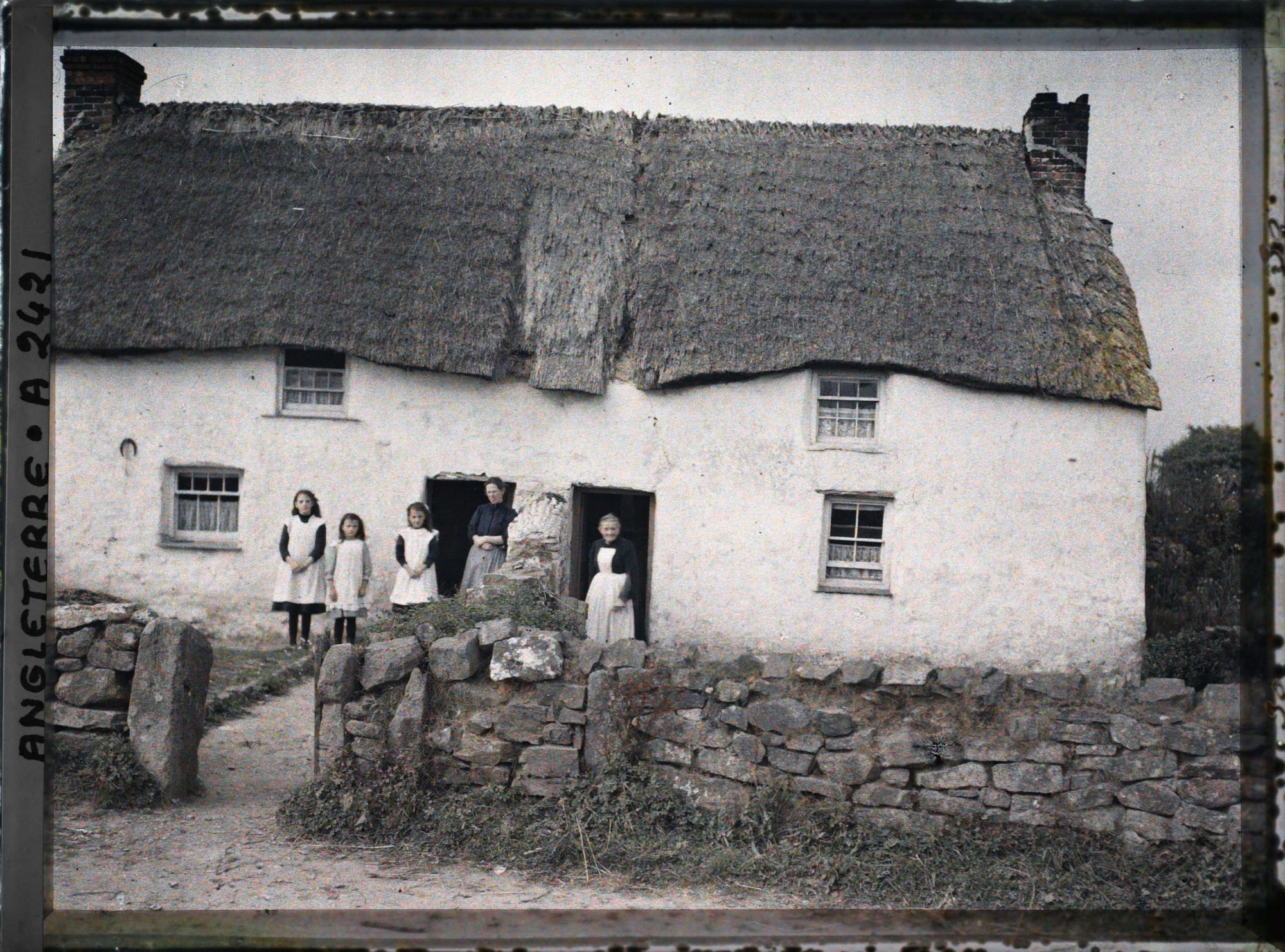 Image représentant Femmes et jeunes filles devant une maison