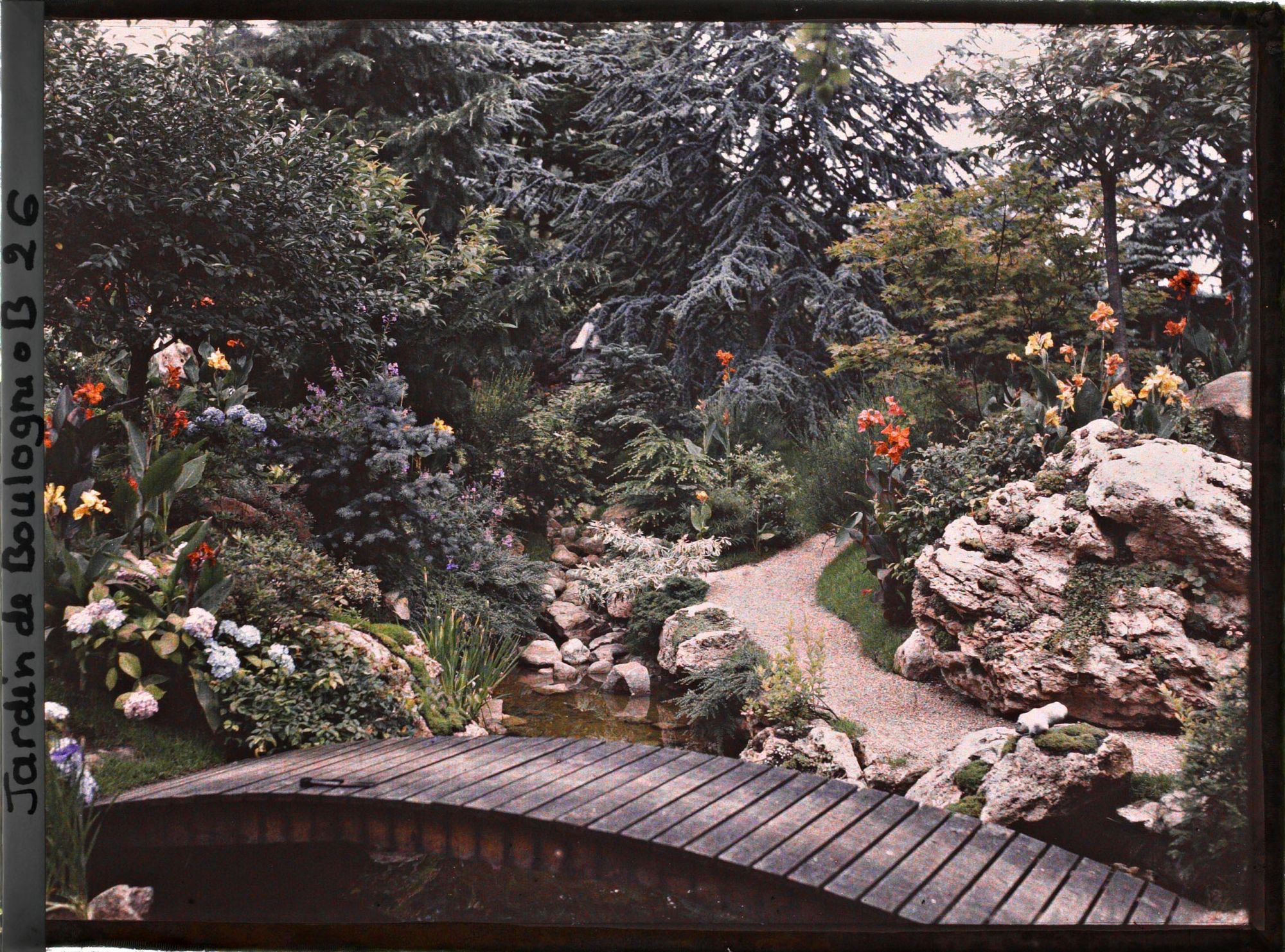 Image représentant Pont du " sanctuaire japonais " reliant un chemin bordé de roches à une rive fleurie