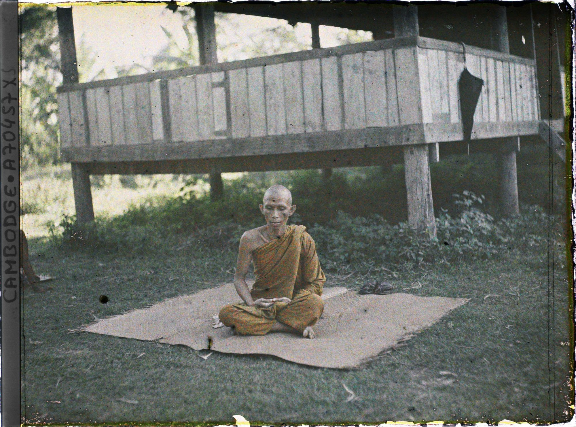 Image représentant Un bonze assis en méditation sur une natte, près de la bonzerie