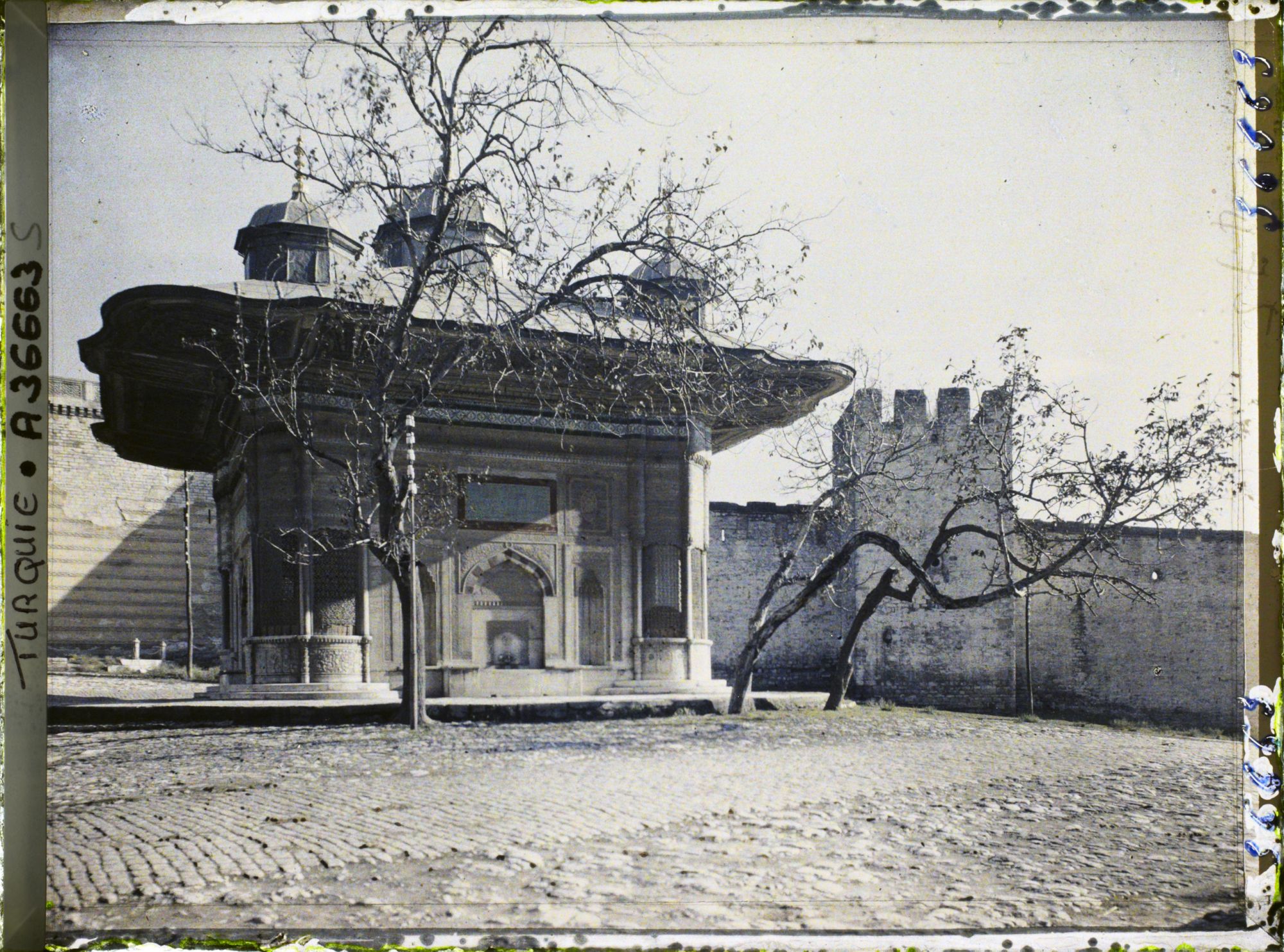 Image représentant Sultan Ahmet Ceshesi ("fontaine du Sultan Ahmet III") devant le mur du palais de Topkapi