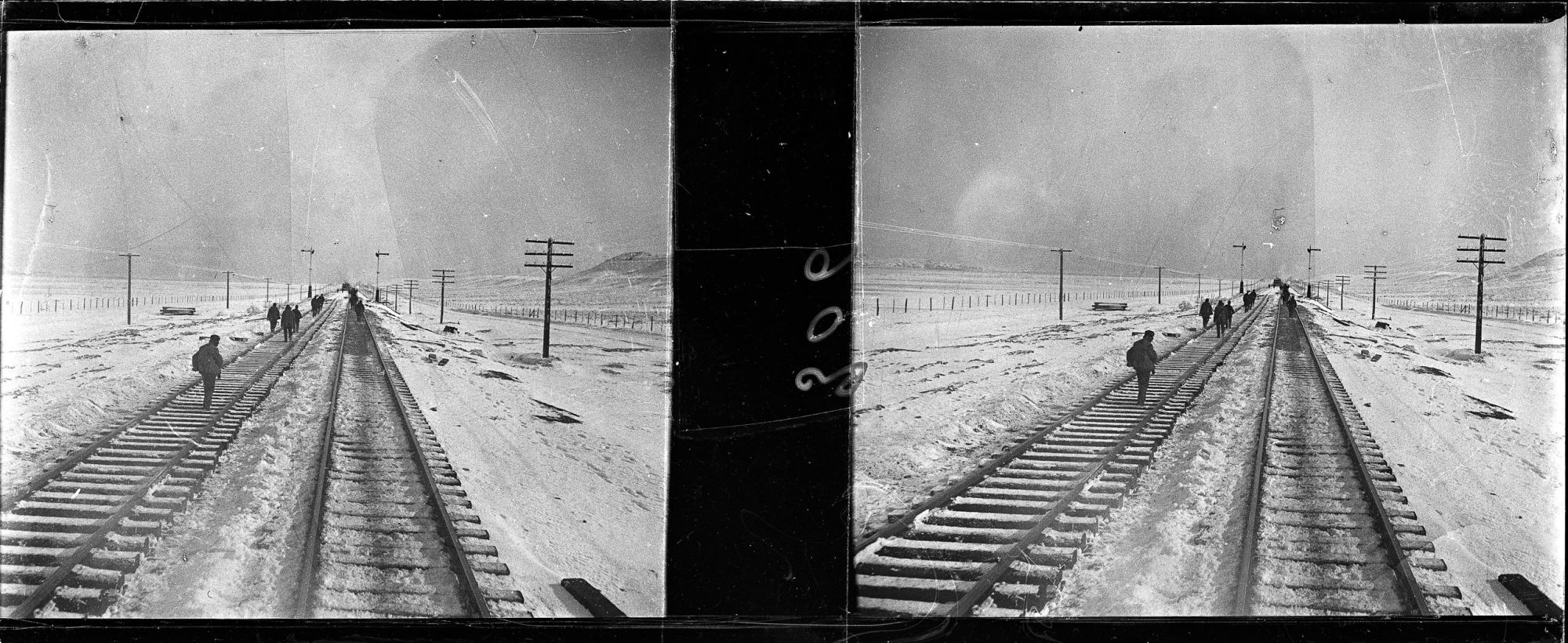 Image représentant des hommes sur les voies ferrées enneigées