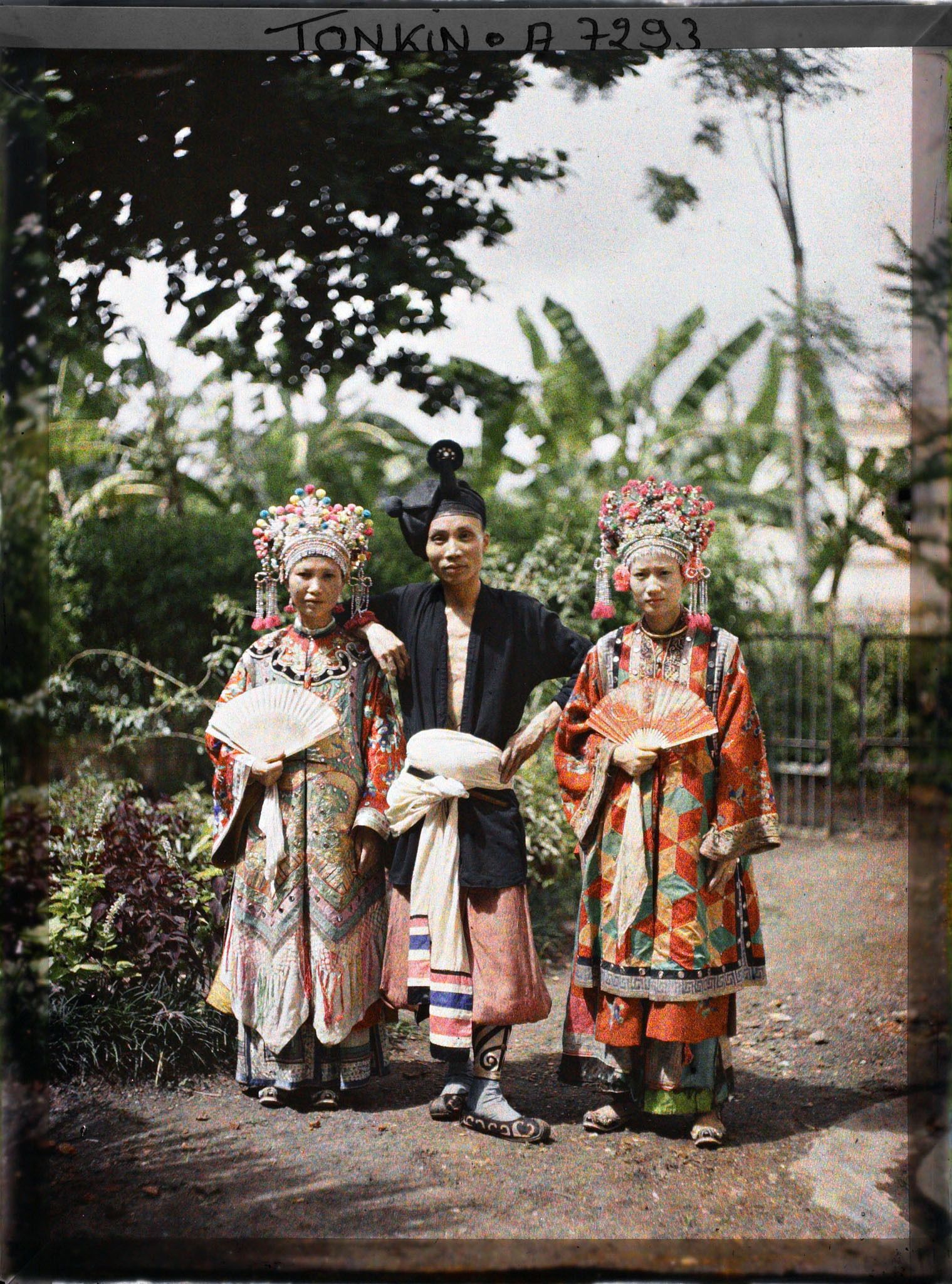 Image représentant Deux actrices et un acteur du Théâtre Saïgonnais, en costume de scène, dans un jardin