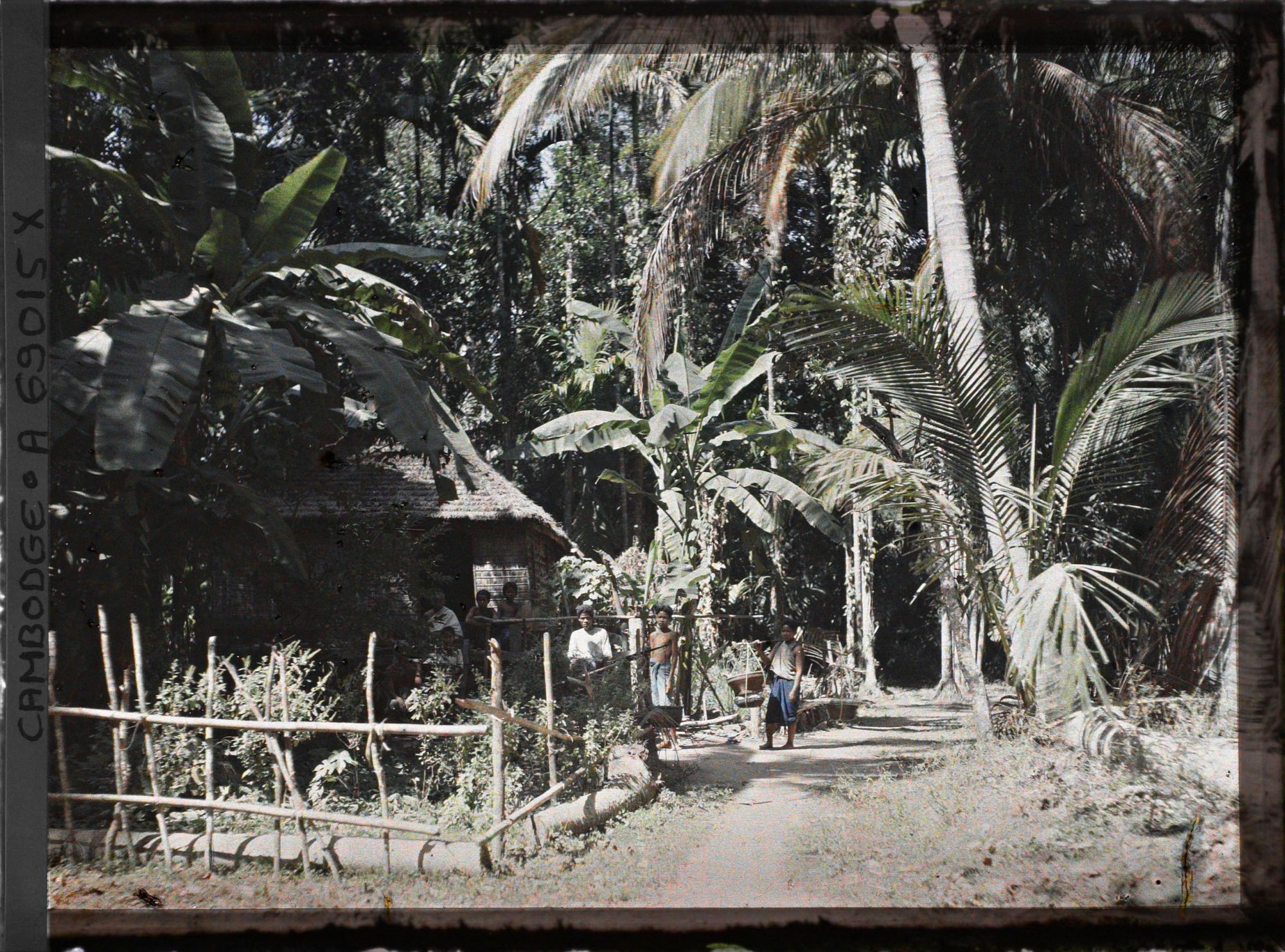 Image représentant Un groupe de villageois, devant une maison avec jardinet et enclos, à la lisière de la forêt