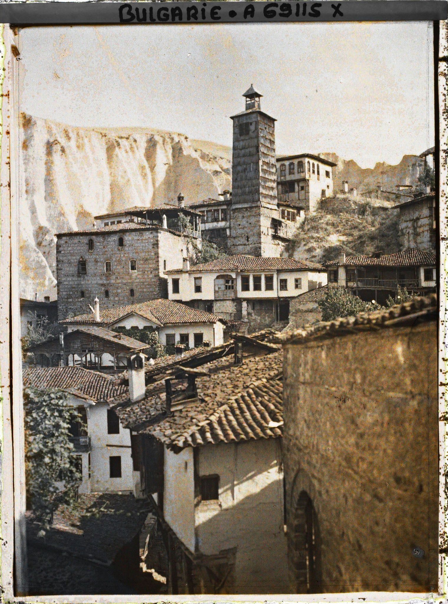 Image représentant Maison et tour de bois dans la partie haute de la ville avec à l'arrière-plan les falaises de grès