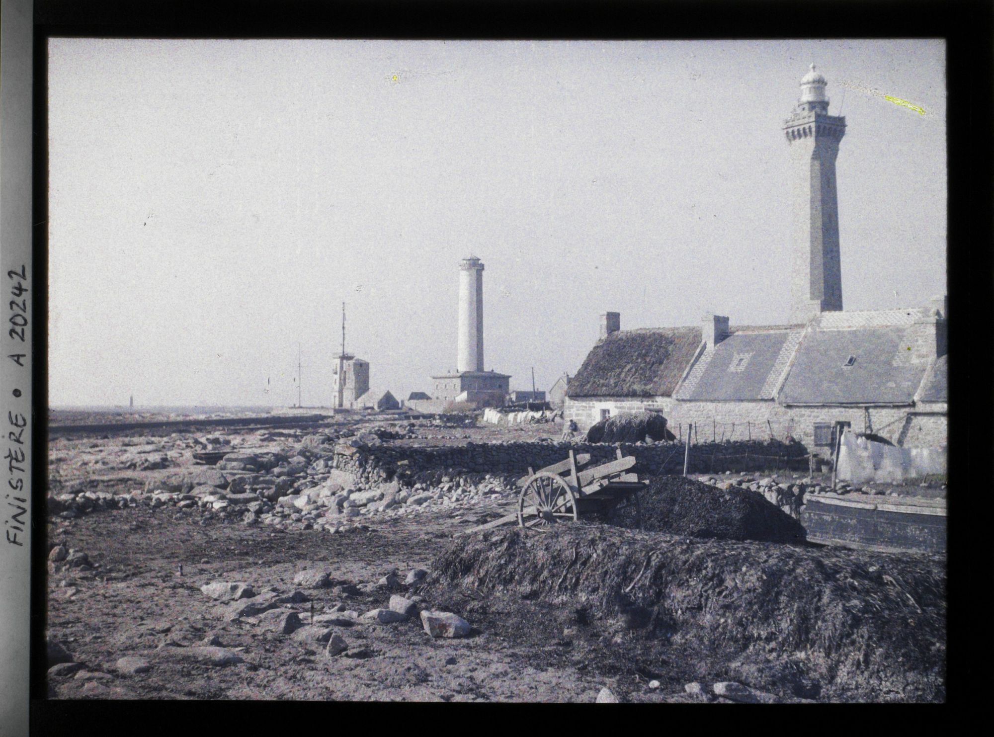 Image représentant Village de Saint-Pierre à la pointe de Penmarch avec, dans le lointain, la tourelle Men-Hir puis le sémaphore et la tour de la chapelle Saint-Pierre, le vieux phare de Penmarch et celui d'Eckmühl