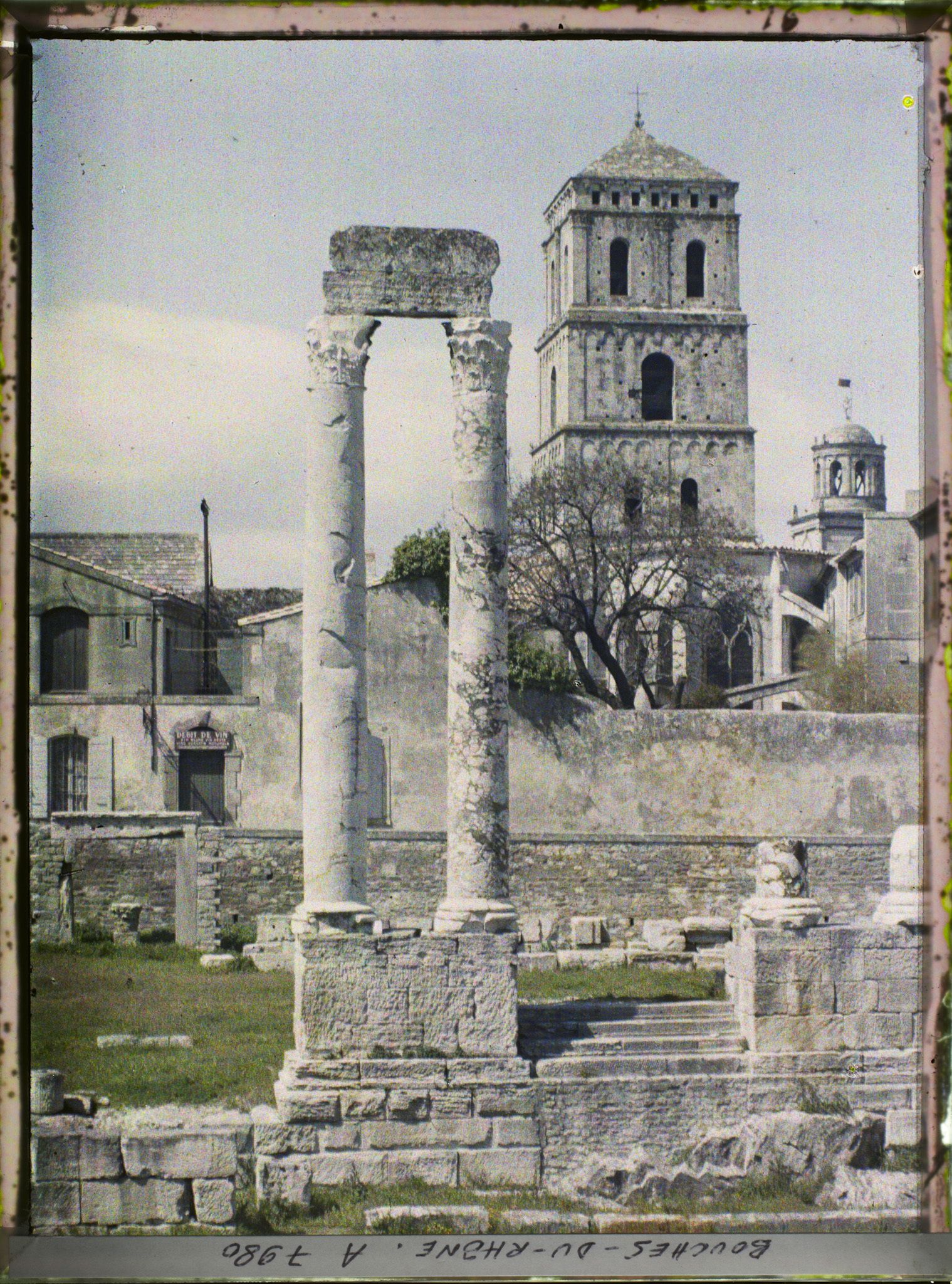 Image représentant Les colonnes du théâtre antique, avec le clocher de l'église Saint-Trophime