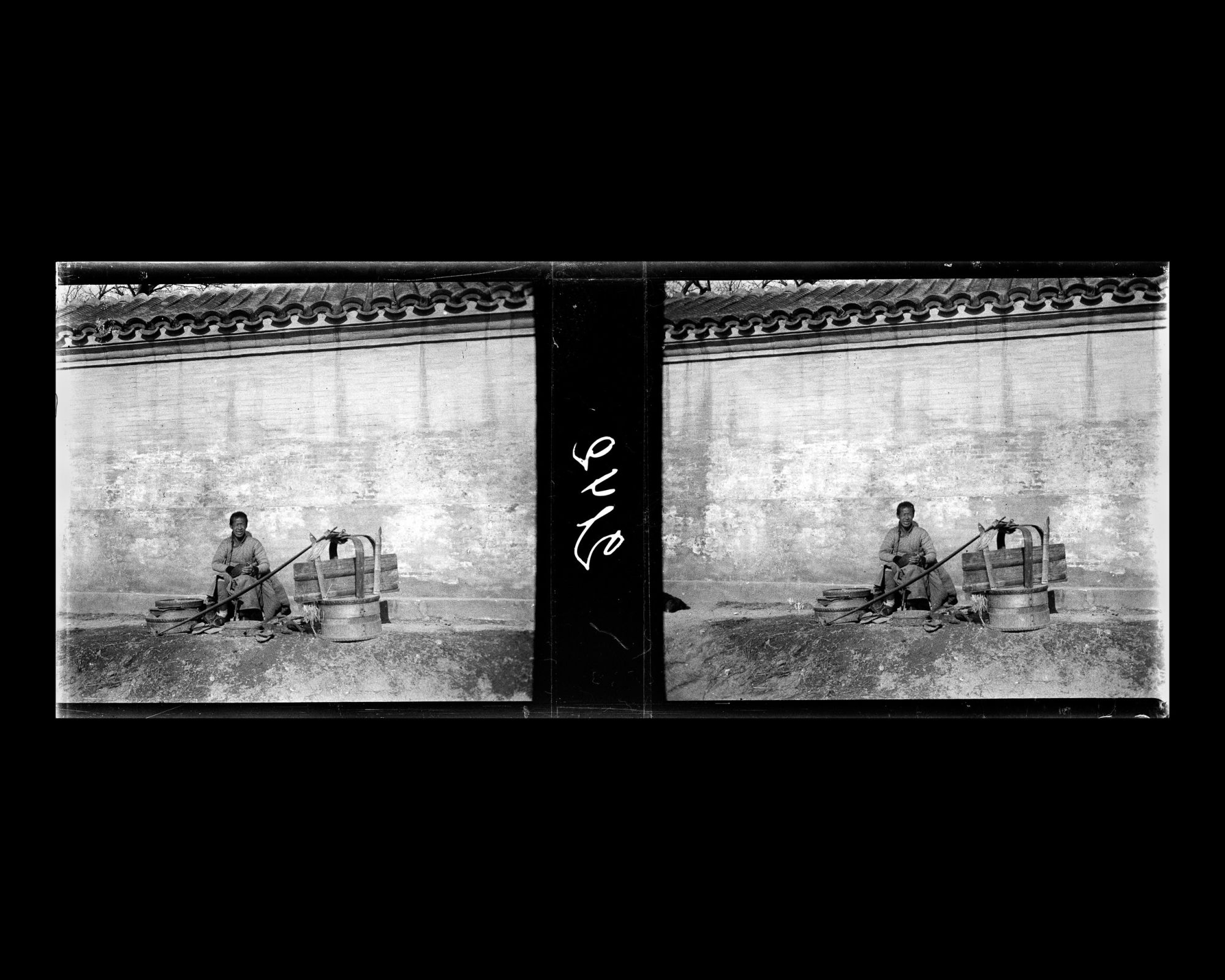 Image représentant Un cordonnier ambulant au travail, assis au pied d'un mur d'enceinte, probablement à l'ouest de Donghuangsi ("temple Jaune de l'Est")