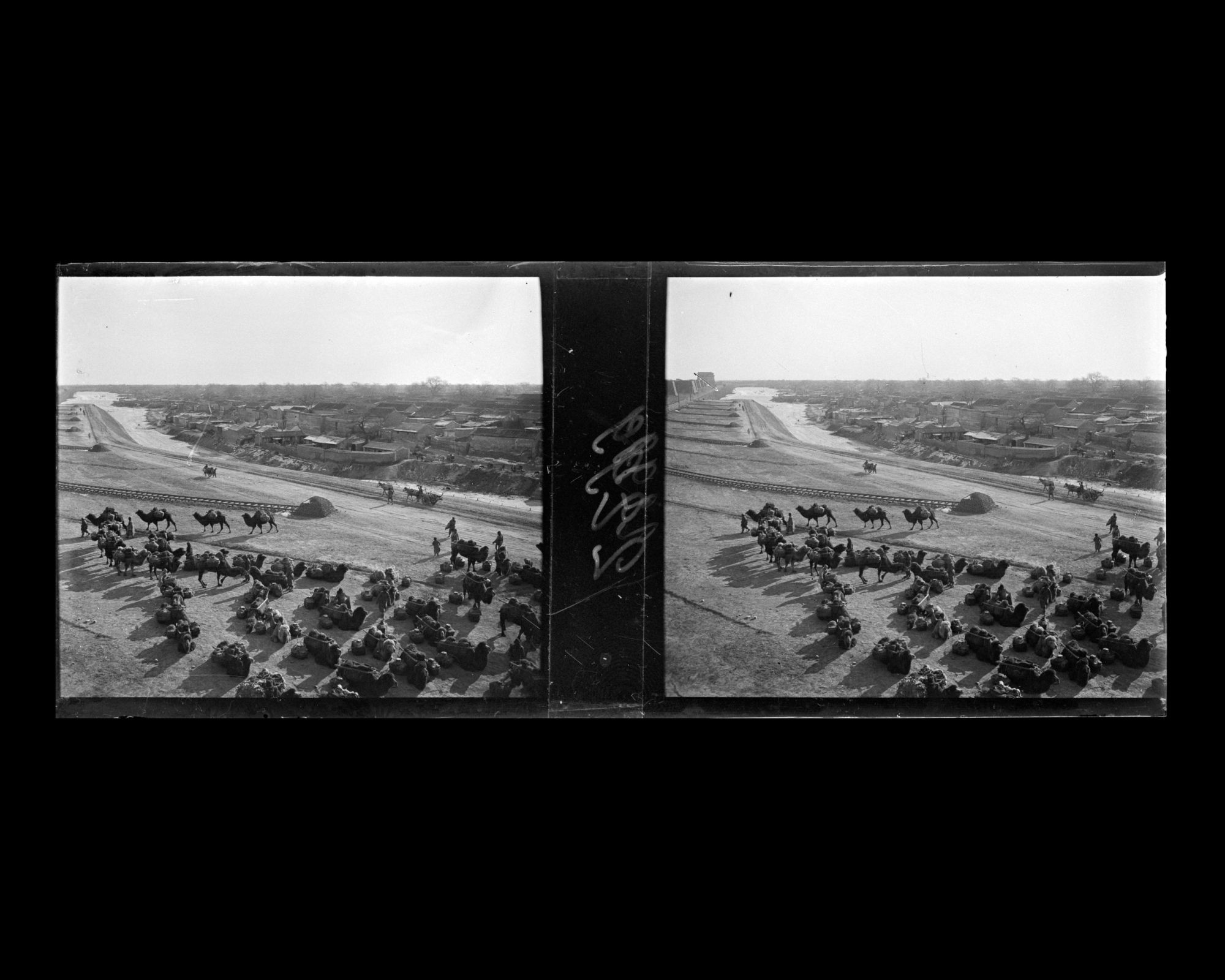 Image représentant Des caravanes de chameaux près de voies de garage des trains de marchandises, aménagées sur un terre-plein le long des douves, entre Chongwenmen ("porte de la Vénération des Lettres"), ou Hadamen, et la tour d'angle sud-est de la ville tartare.