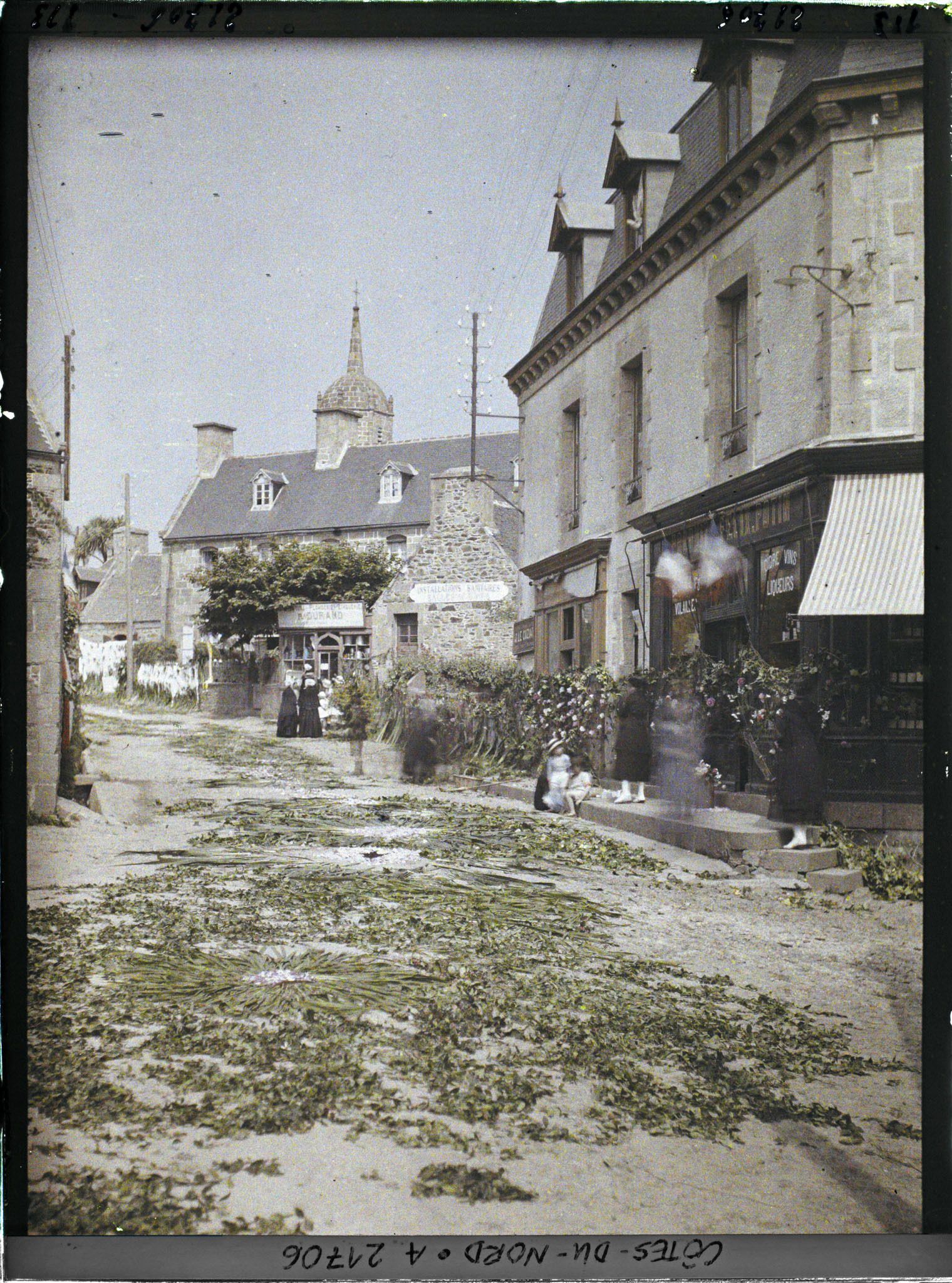 Image représentant La rue de l'Eglise (aujourd'hui rue du Maréchal Joffre) décorée pour la procession de la Fête-Dieu