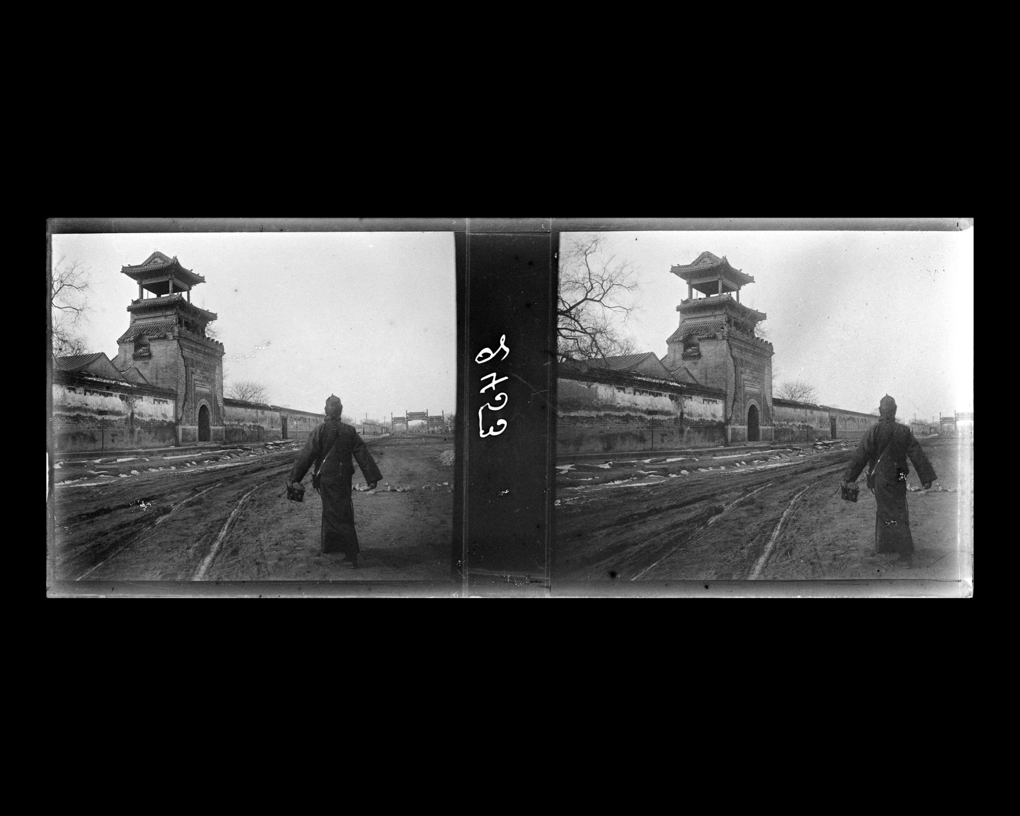 Image représentant un homme de dos sur Xichanganjie ("rue Ouest de la Paix Éternelle") bordée par un mur d'enceinte et le minaret d'une mosquée