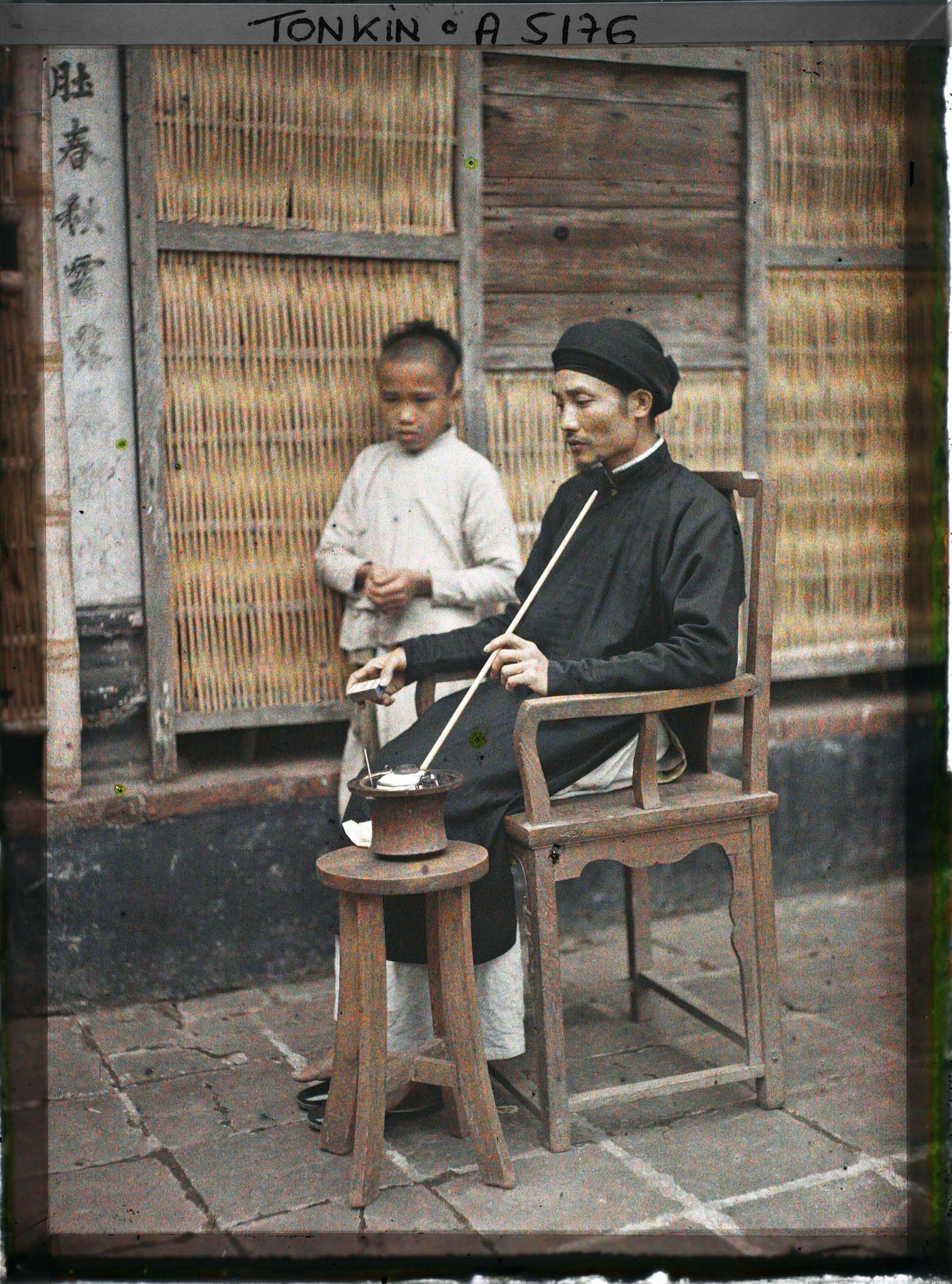 Image représentant Un maire de village fumant sa pipe à eau dans la cour intérieure de sa maison