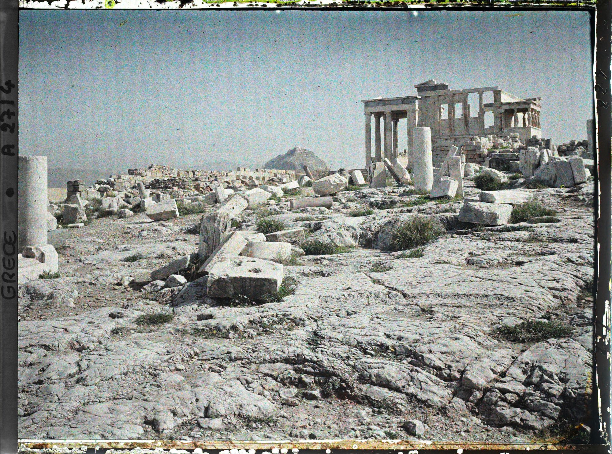 Image représentant Sur l'Acropole vestiges de colonnes et de blocs, l'Erechtheon vu dans son ensemble (à droite) et au fond, le mont Lycabette