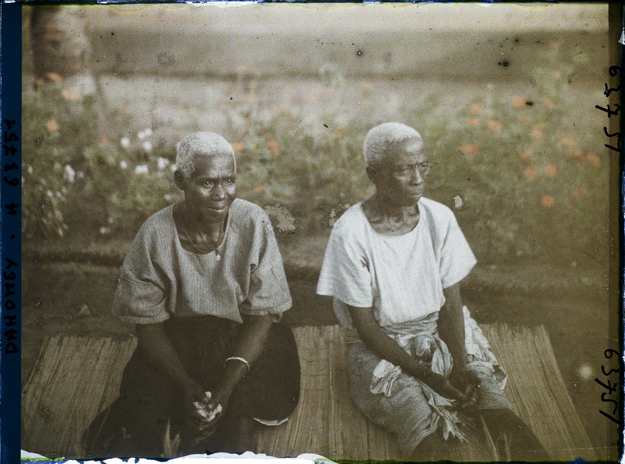 Image représentant Deux femmes âgées assises sur une natte de paille, assistant probablement à un cours sur le christianisme
