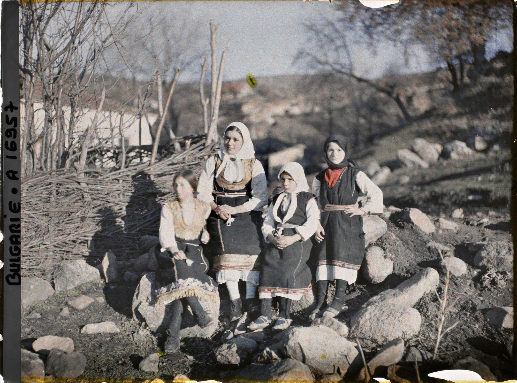 Image représentant Groupe de jeunes filles devant un mur de petit bois avec à l'arrière-plan l'église