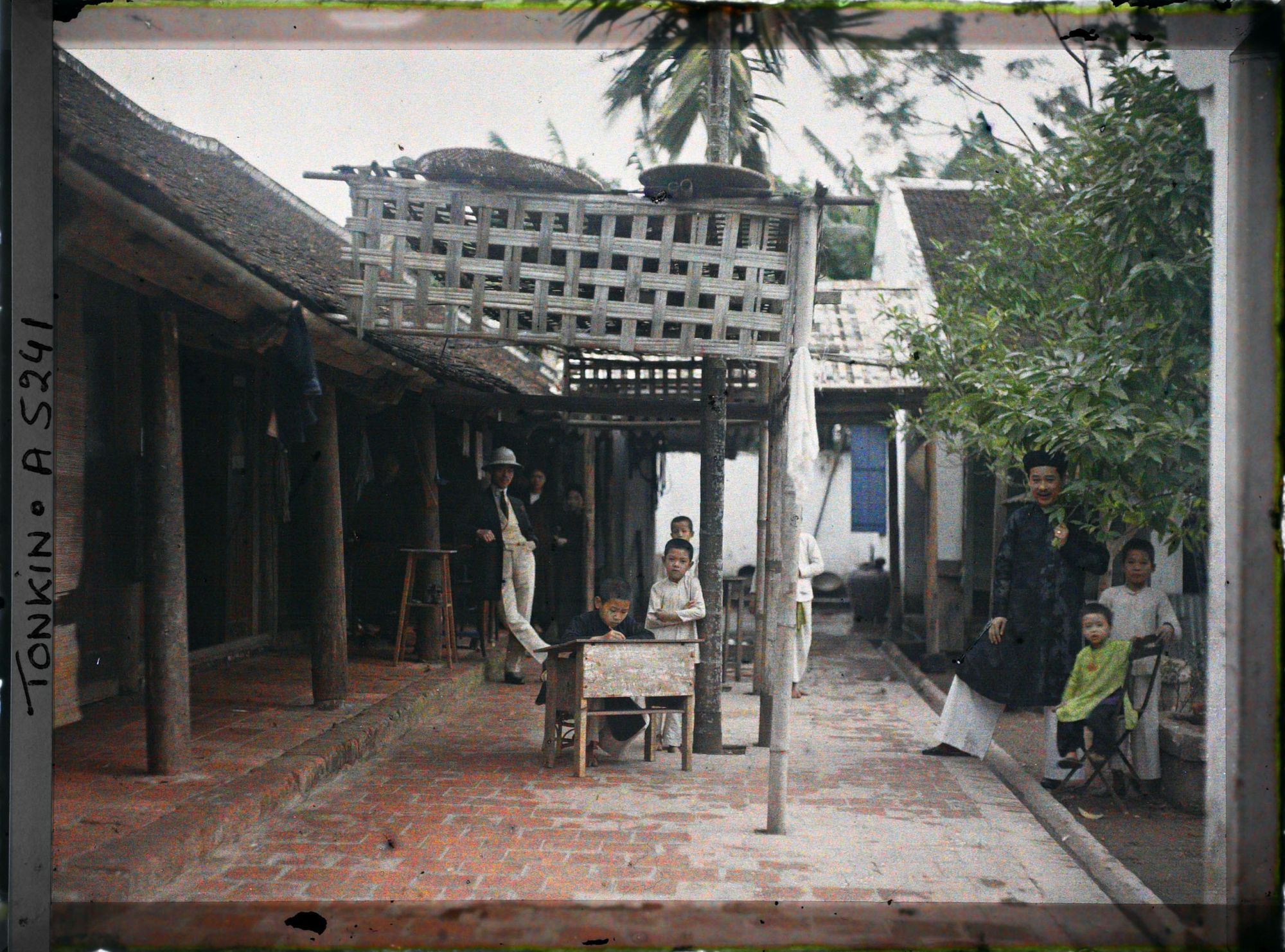 Image représentant Des enfants et des hommes dans la cour d'une maison aisée