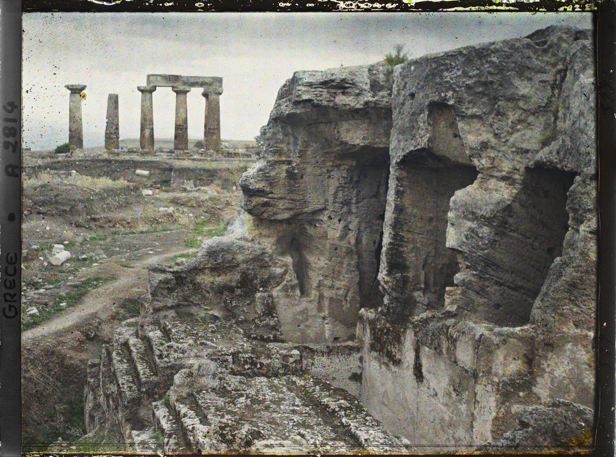 Image représentant Au premier plan, l'une des trois absides à trois niches de la Fontaine Pirène inférieure. A l'arrière plan, colonnes du Temple d'Apollon