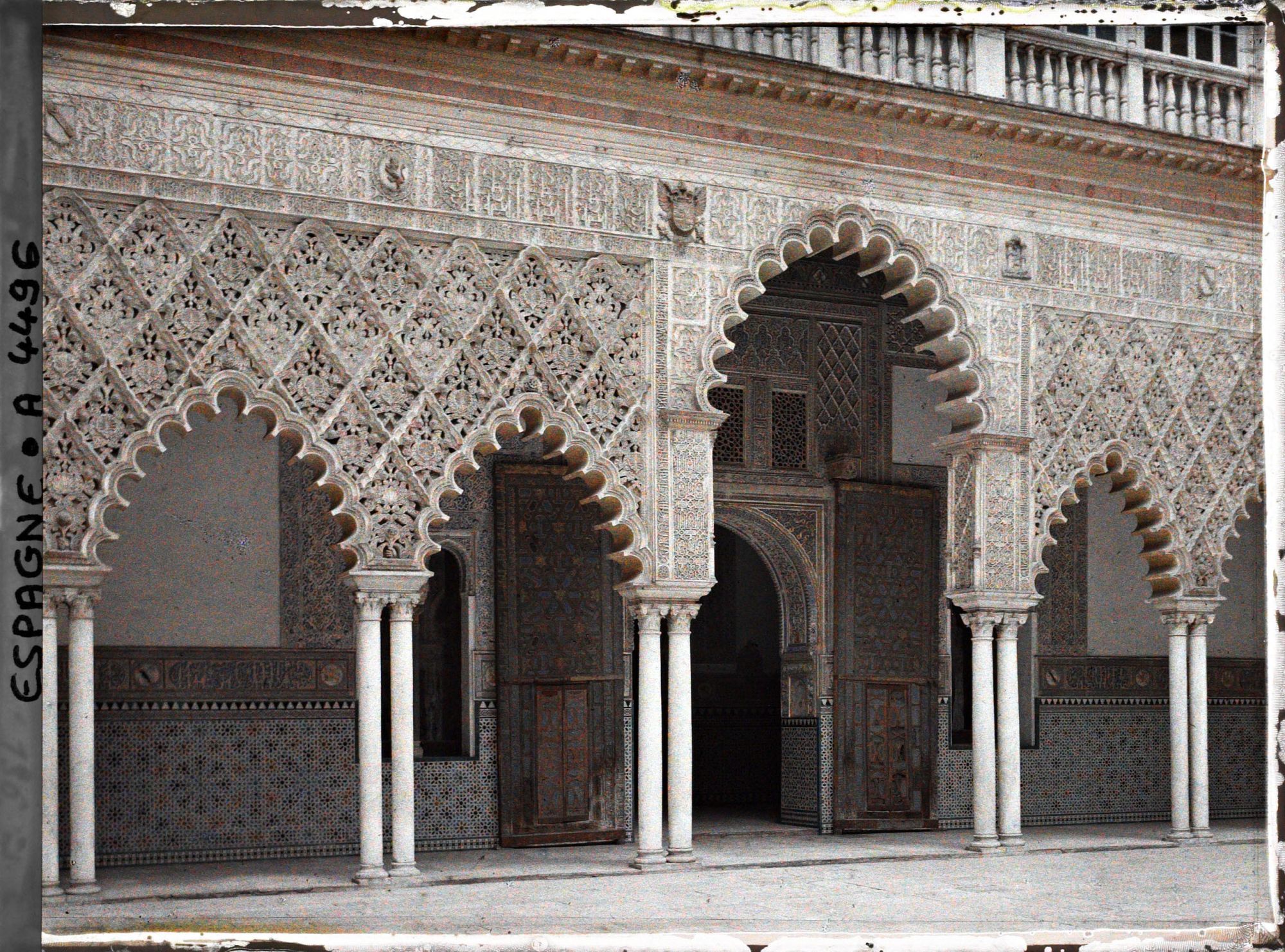 Image représentant Alcazar : les arcades du patio de las Doncellas ("des Demoiselles") et la porte vers le salon de Embajadores ("des Ambassadeurs")