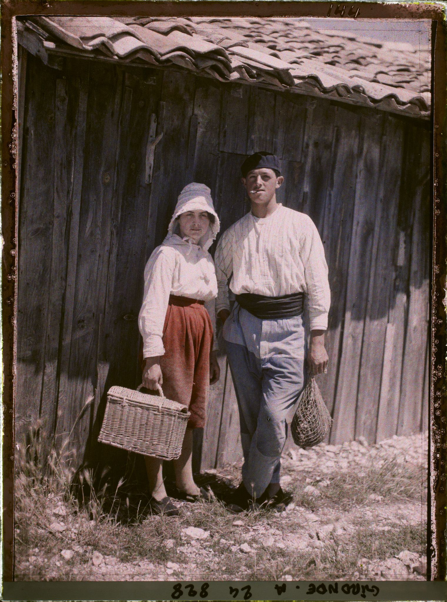 Image représentant Un couple de pêcheurs, portant panier et nasse