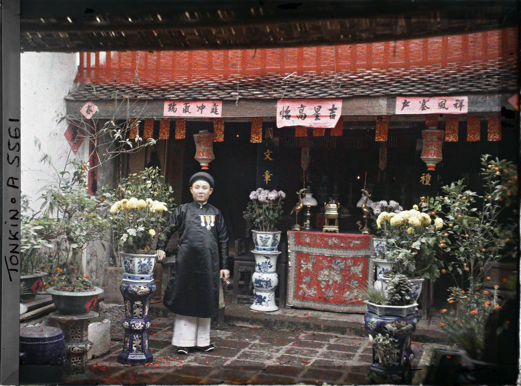 Image représentant Un notable près de l'autel des ancêtres dans la cour d'une maison aisée, au moment de la fête du Têt