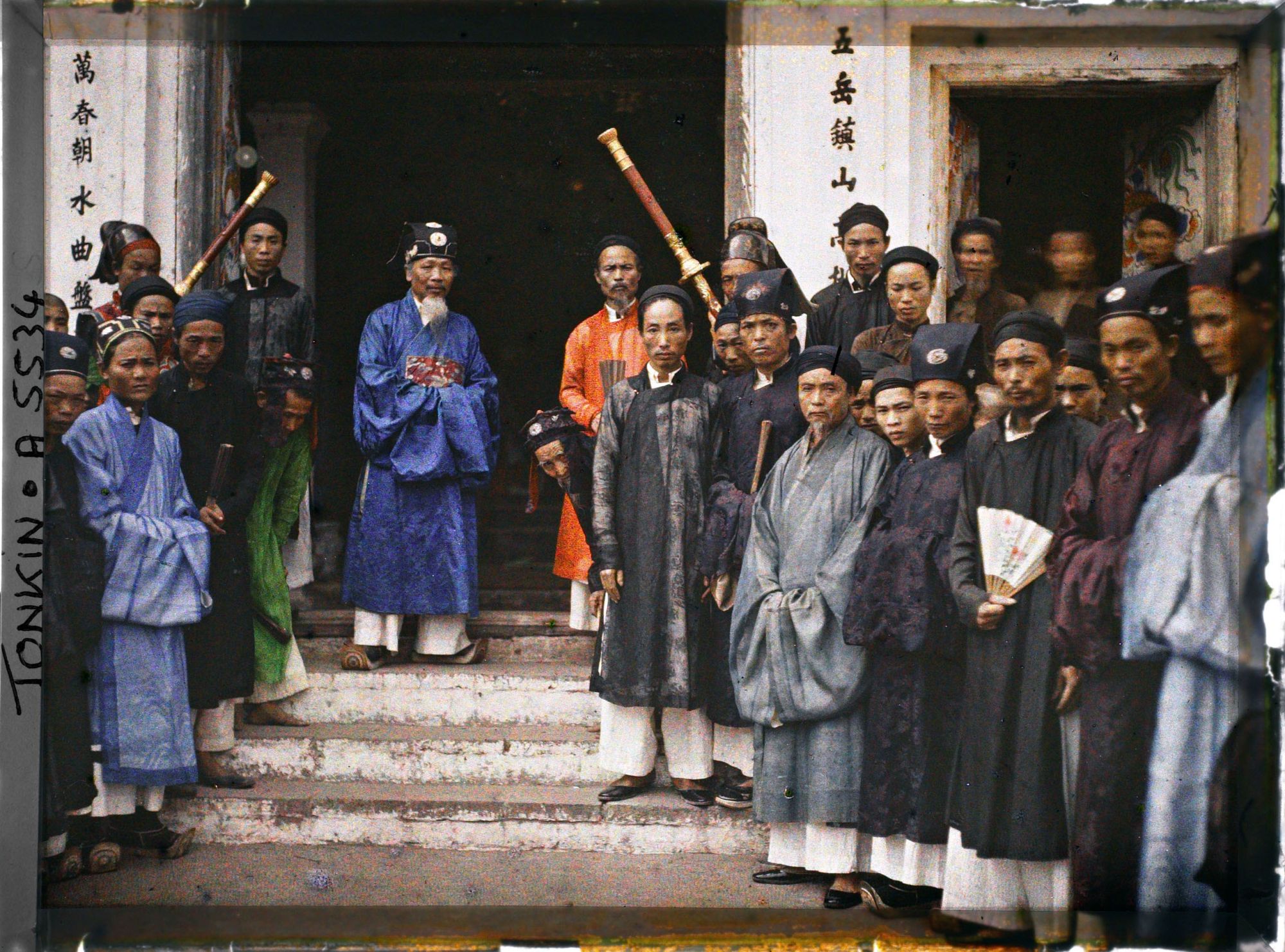Image représentant Le chef de canton et les autorités villageoises réunis devant le Dinh (maison communale)