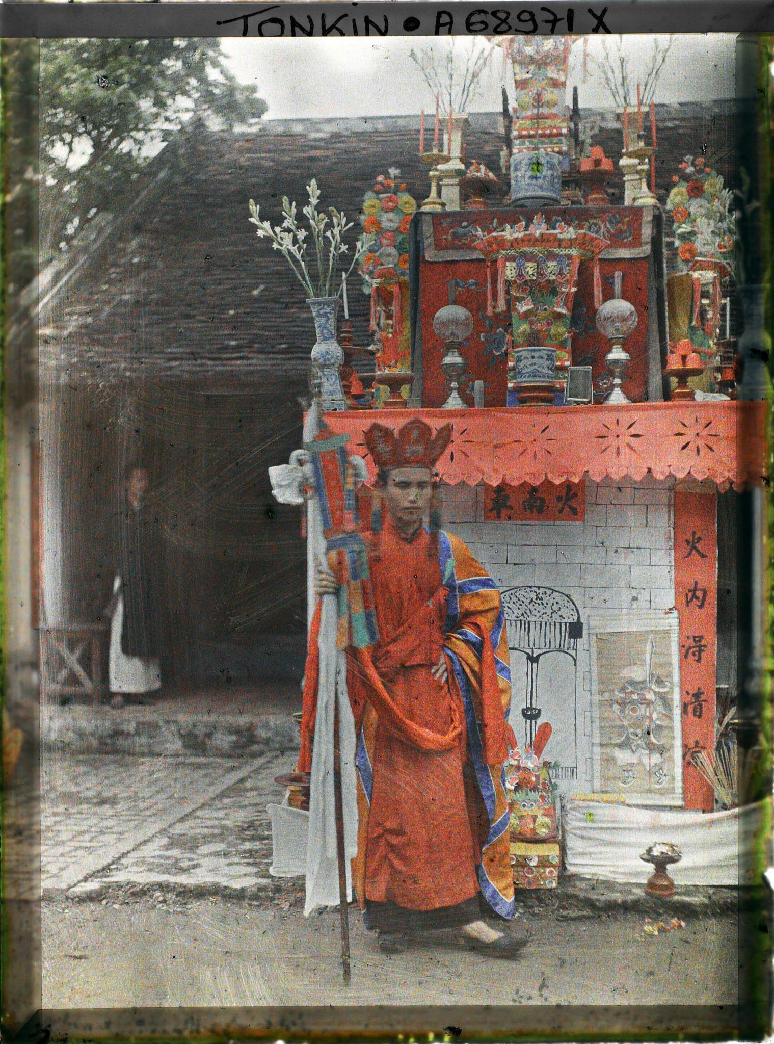 Image représentant Le Thay-phu-thuy devant l'édicule symbolisant la prison infernale aux portes gardées par des images de démons