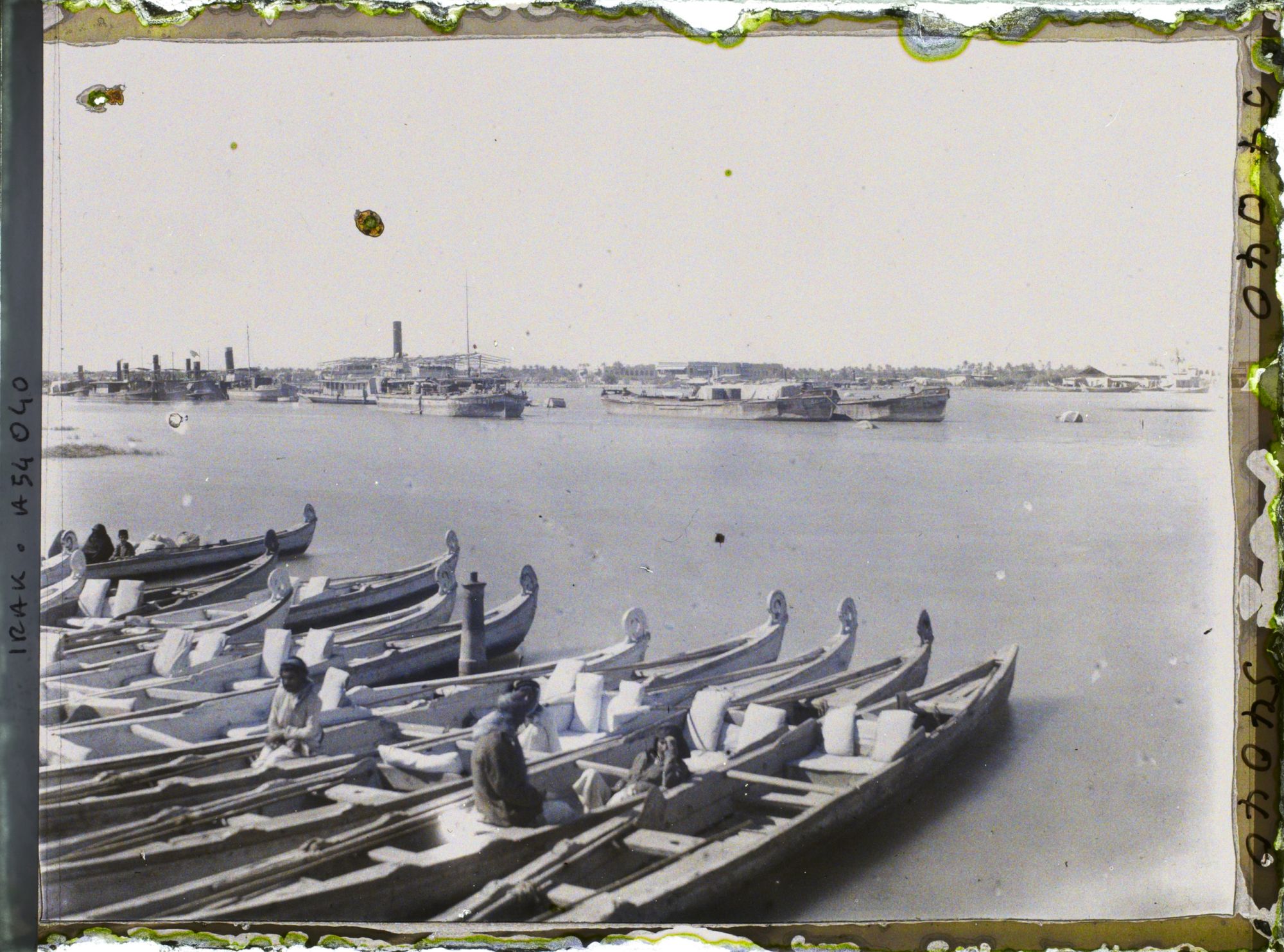 Image représentant La ville, vue sur la rive gauche du Chatt al 'Arab ; au premier plan, des bateaux Belems