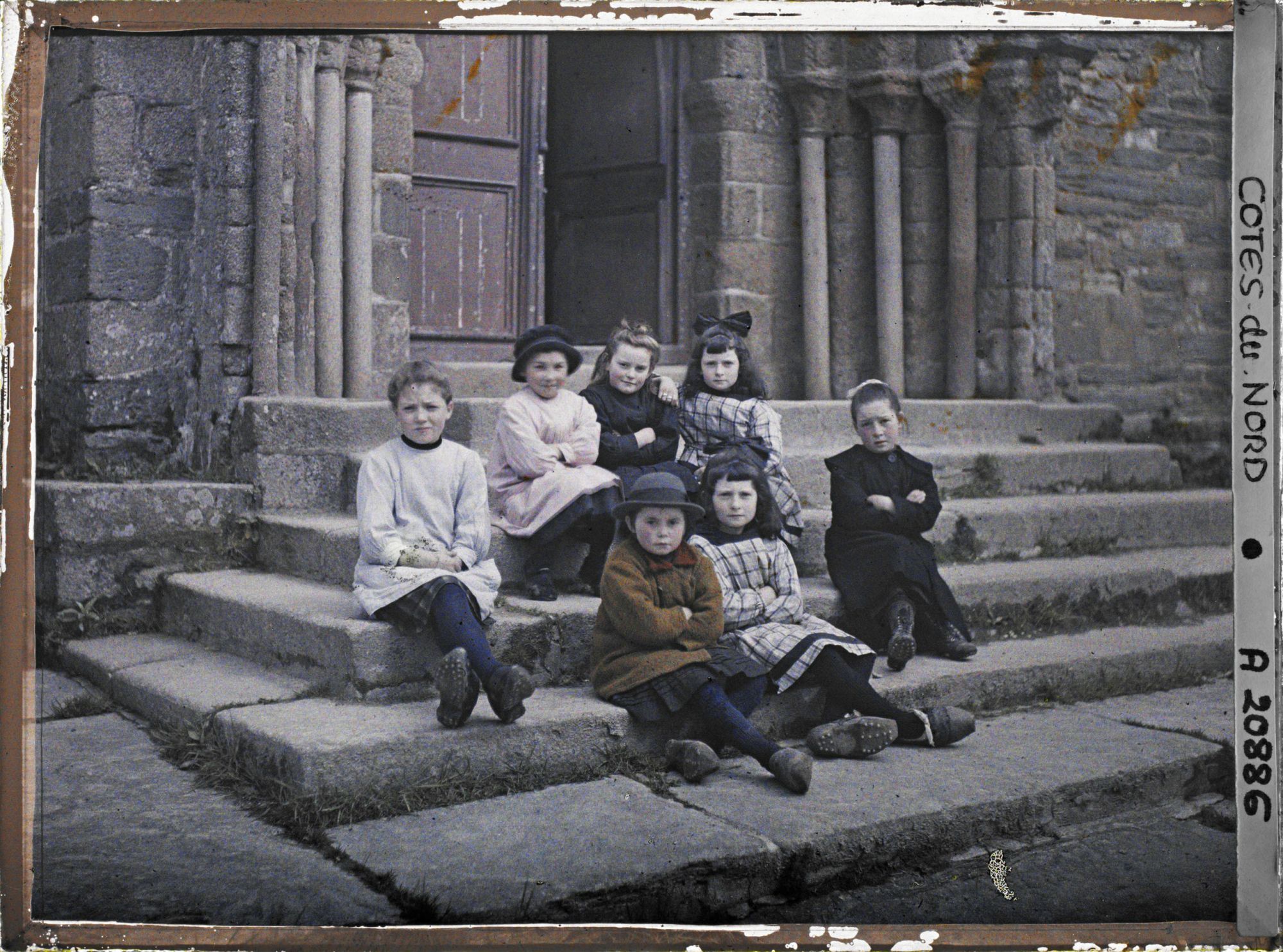 Image représentant Groupe de petites filles assises devant l'église de la Trinité de Brélévenez