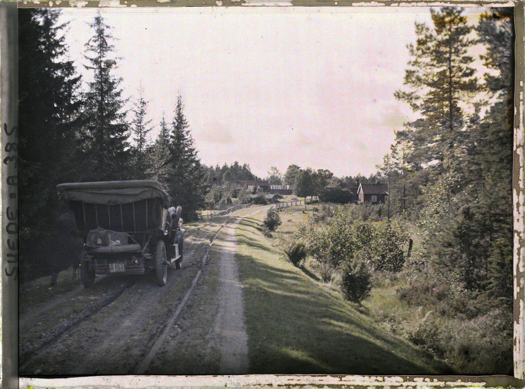 Image représentant Andeers Beer Wilse prenant une photographie près de la voiture de location, arrêtée sur une route à l'entrée d'un village
