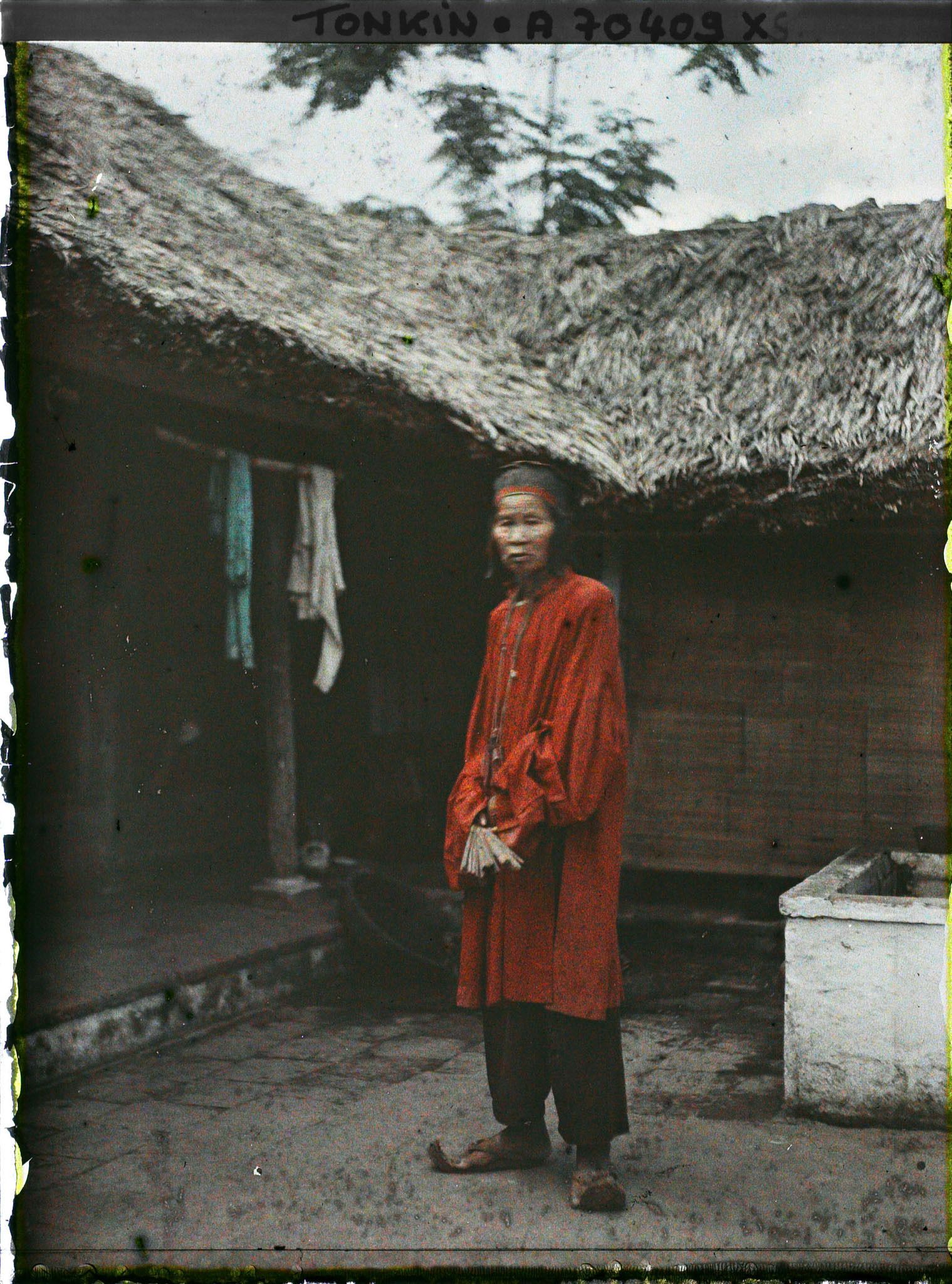 Image représentant Un notable de village en costume de cérémonie à l'occasion d'un mariage, assis dans une cour intérieure