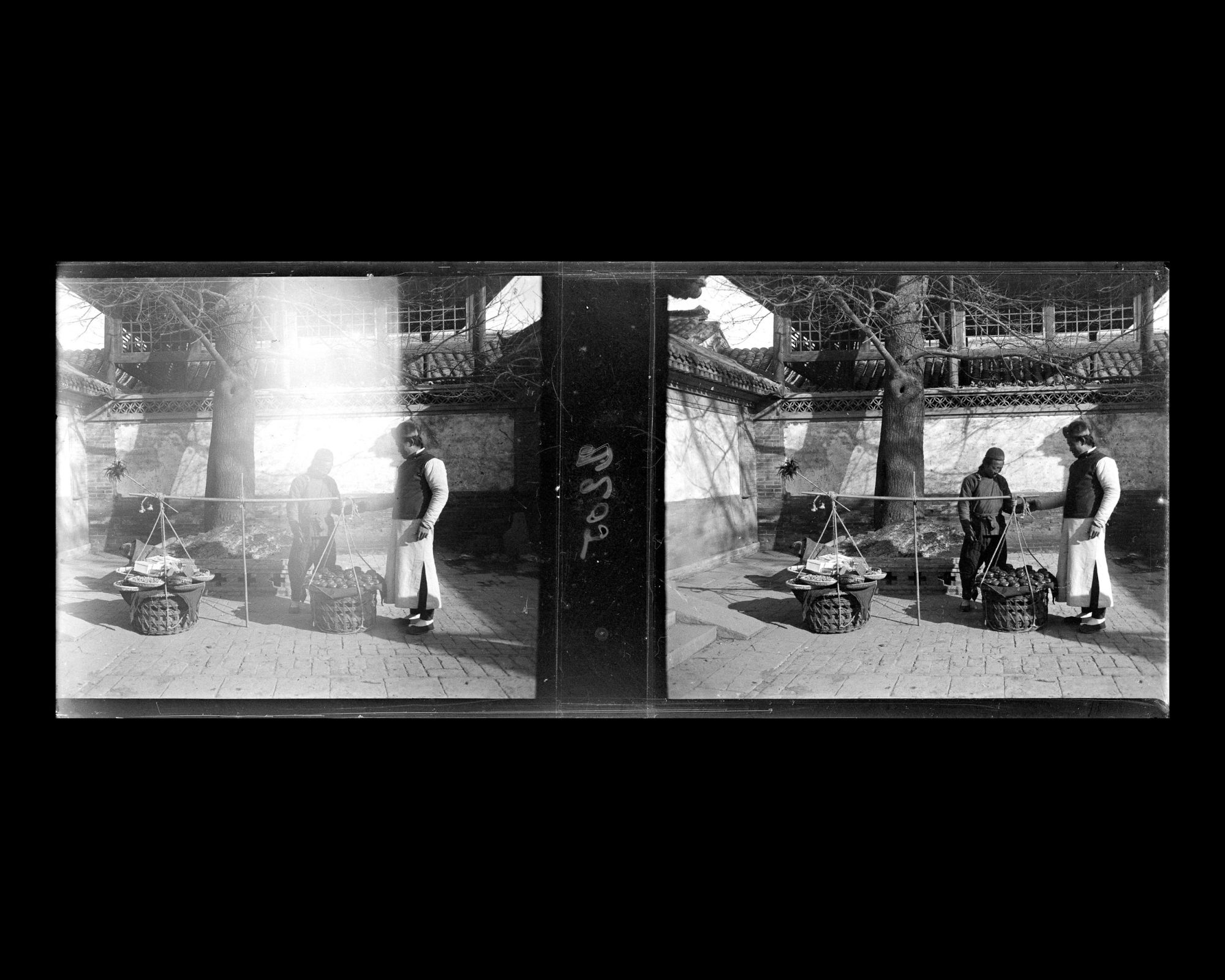 Image représentant Un marchand ambulant propose à son client des kakis dans la première cour d'une résidence (siheyuan) de Da Ruanfuhutong ("Grande Ruelle de la Résidence Ruan")