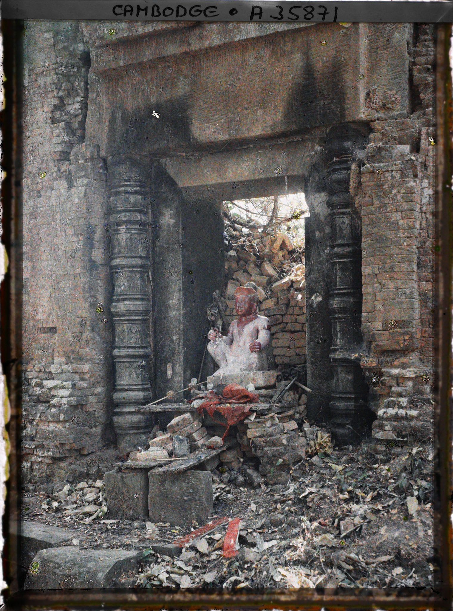 Image représentant Une statue environnée de décombres, au temple de Phnom Bakheng